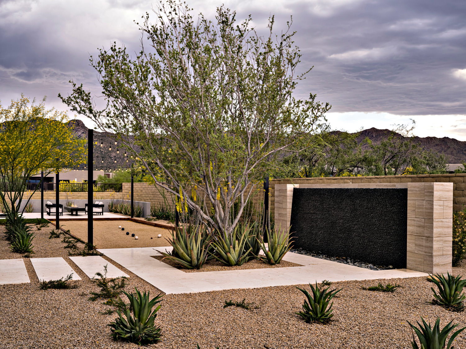 tree rising out of a walkway at a desert home