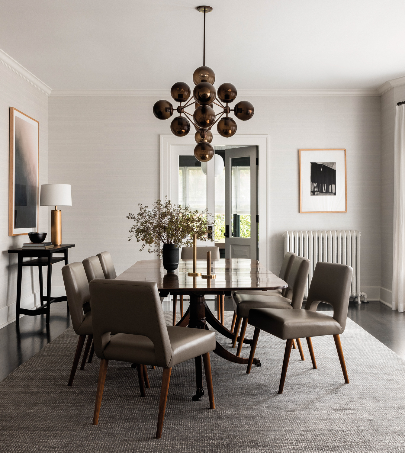 Dining room featuring a chandelier with smoked globes, long table and chairs in Seattle Craftsman