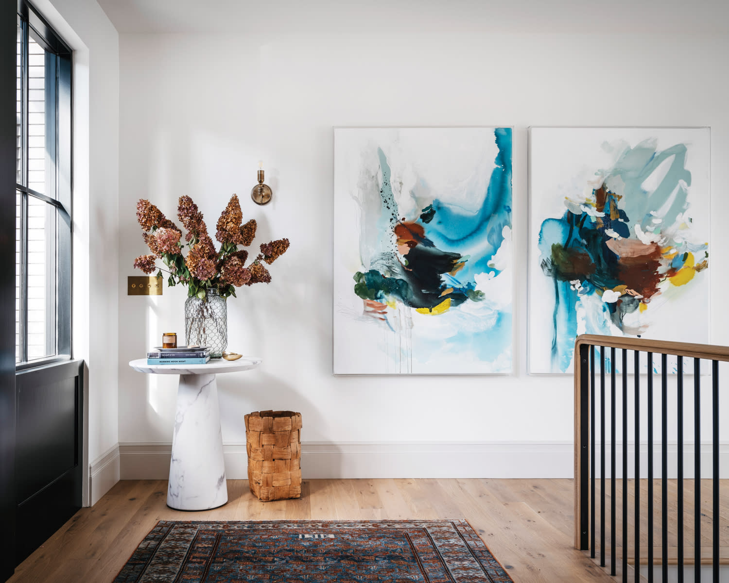 accent table sits below painting in naturally lit entry space in home by Katie LeClercq