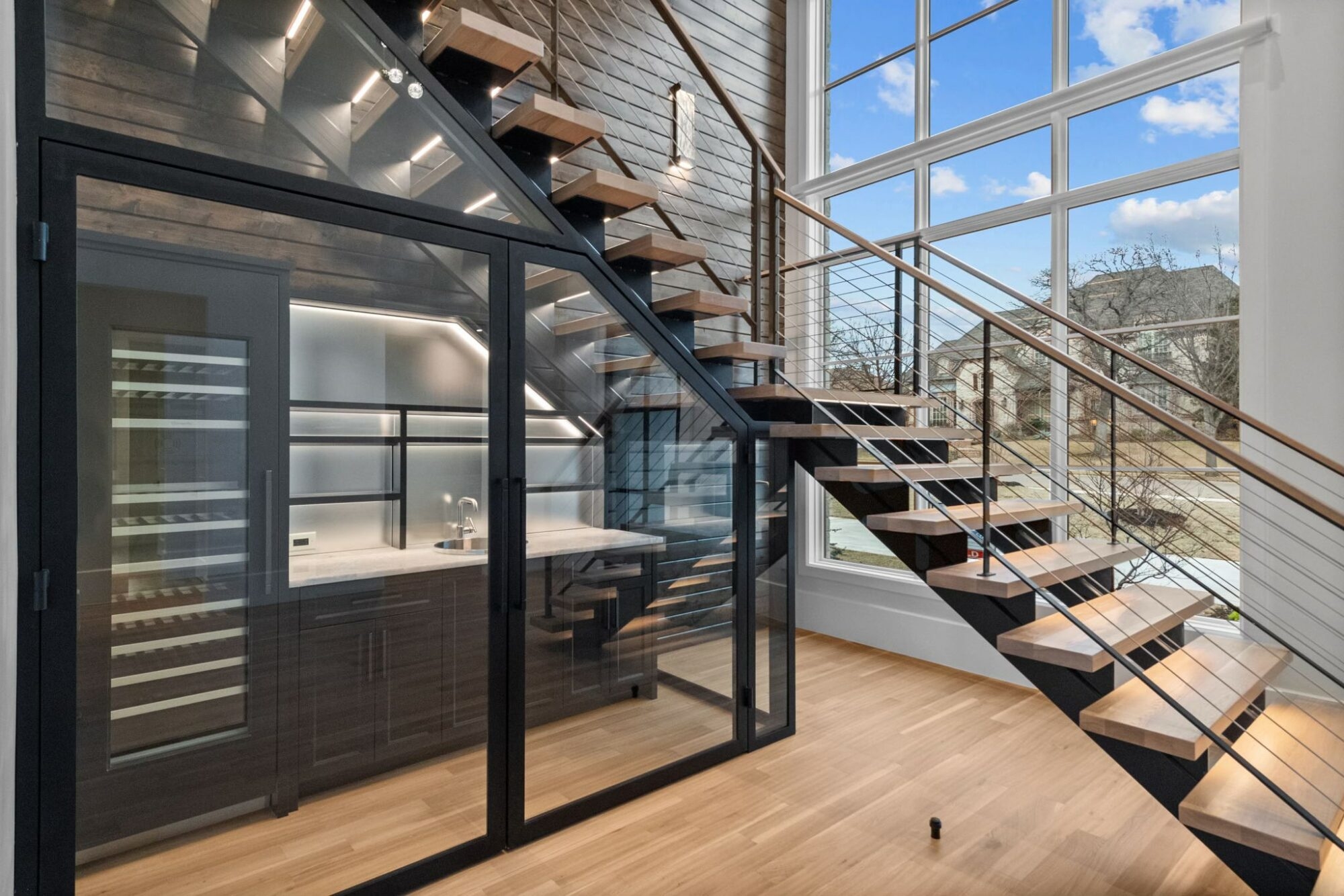 a bar with glass walls underneath the stairs