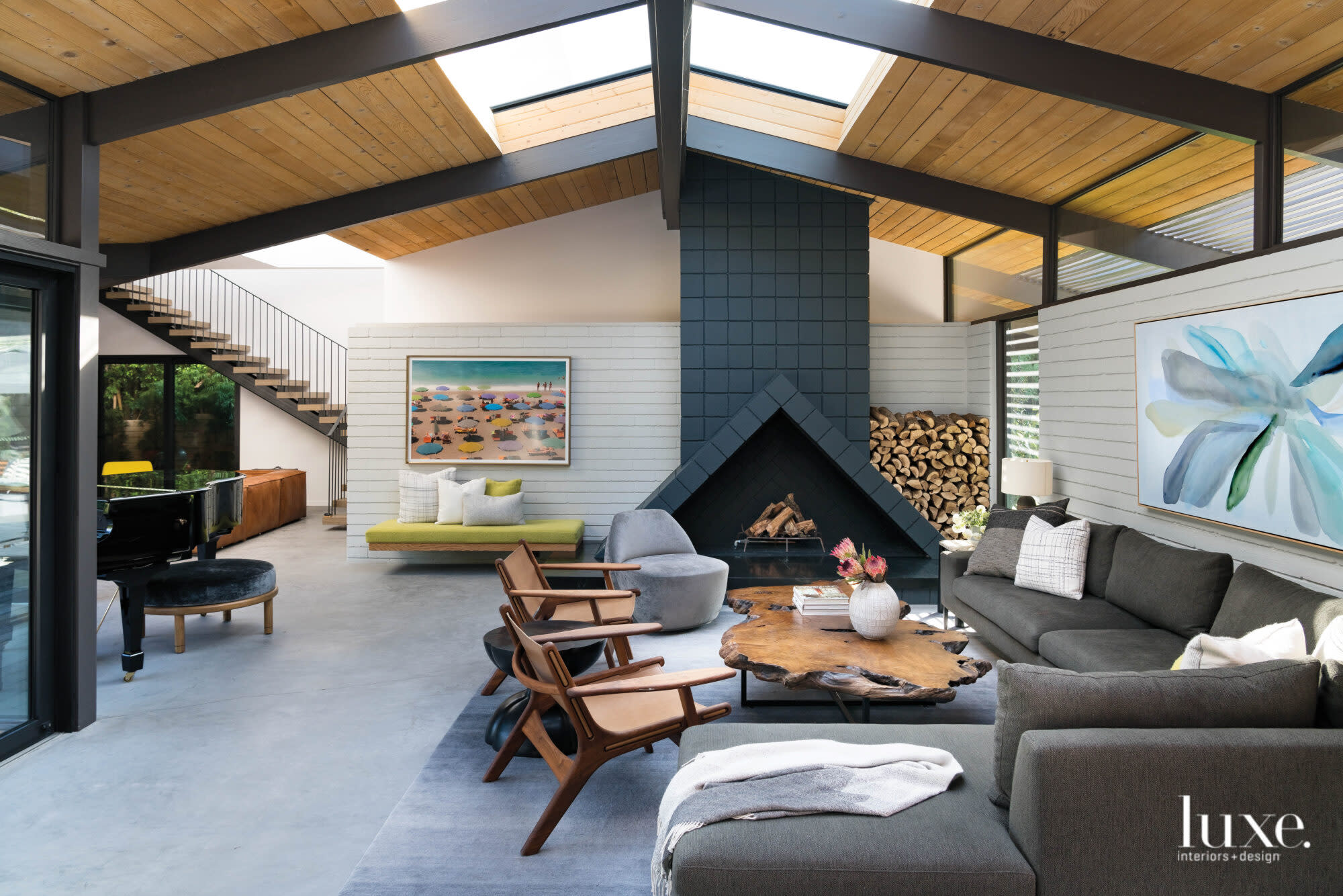 Living room of a midcentury modern house with live edge coffee table and black painted fireplace