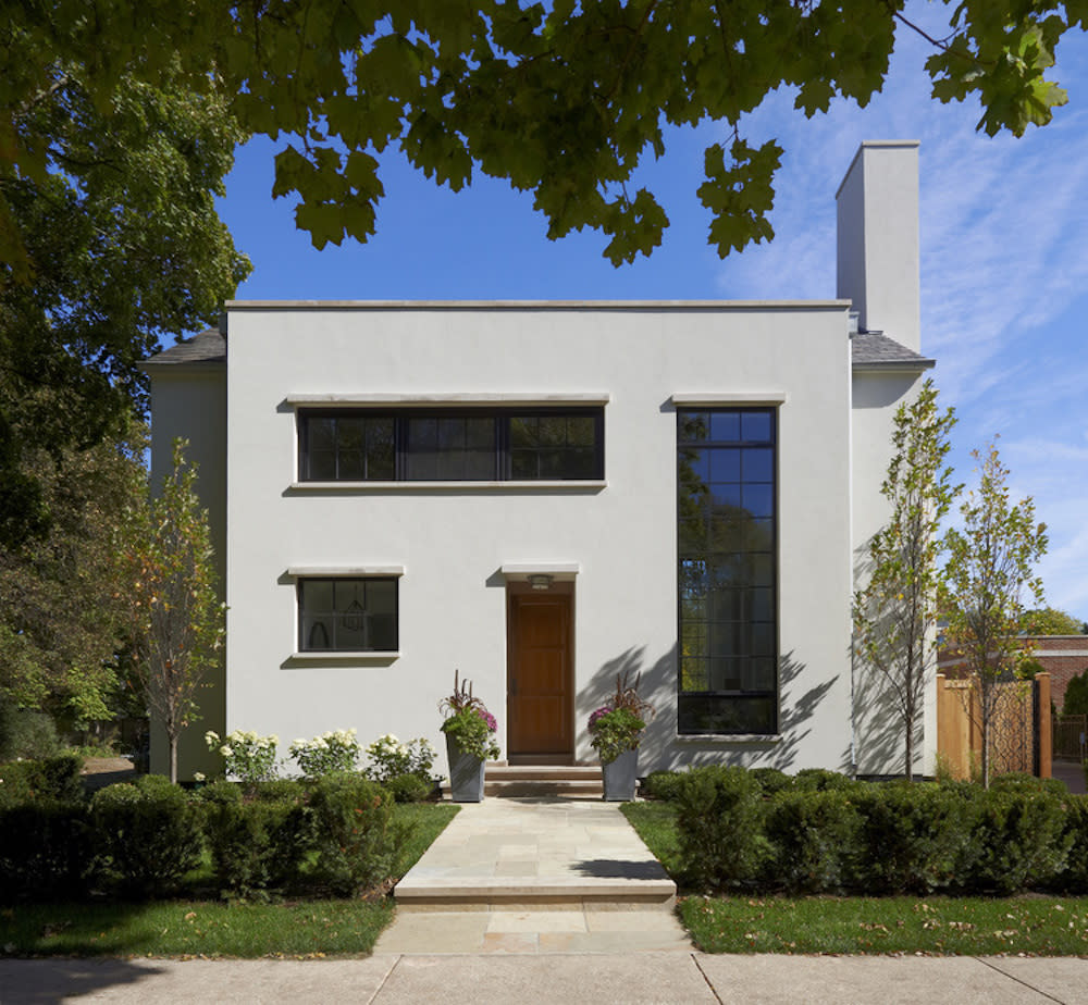 Stucco clad house with large windows and front courtyard