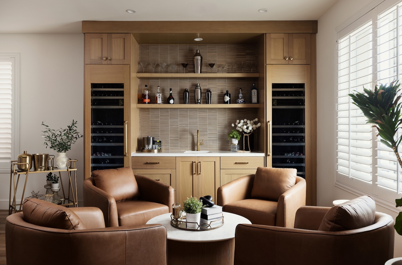 A modern living room with a sleek bar area and inviting chairs, perfect for entertaining guests.