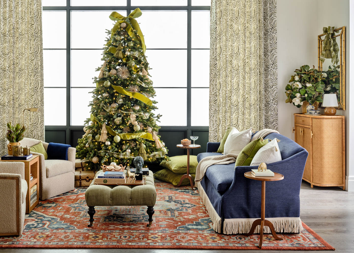 red rug beneath a blue sofa and green coffee table in a living room with a Christmas tree