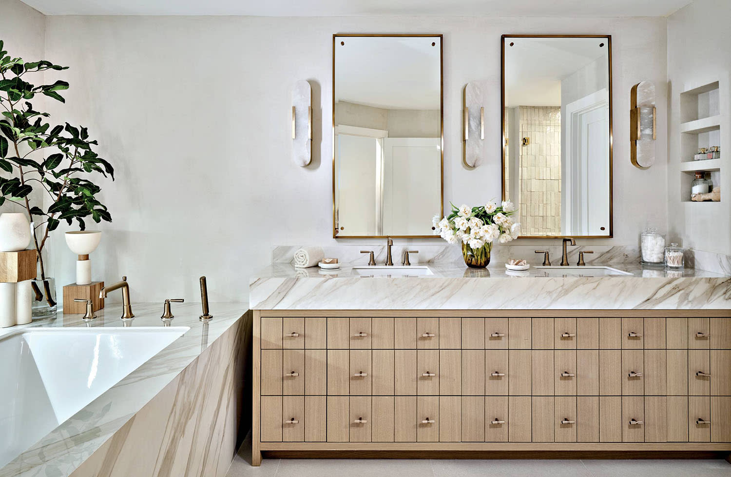 contemporary bathroom with a marble-topped vanity and matching marble-wrapped tub