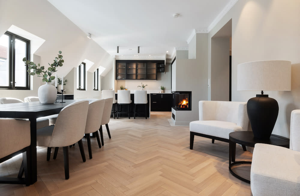 A contemporary dining room featuring a cozy fireplace, European oak flooring and stylish chairs, creating an inviting atmosphere for gatherings.