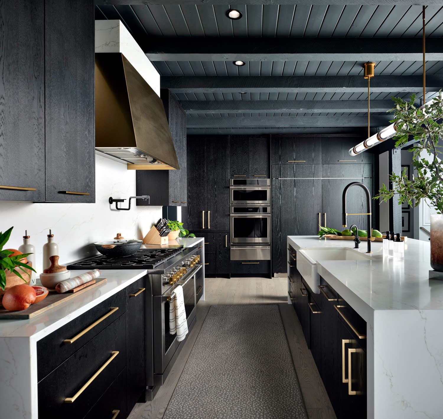 dark and dramatic kitchen with a gold range hood