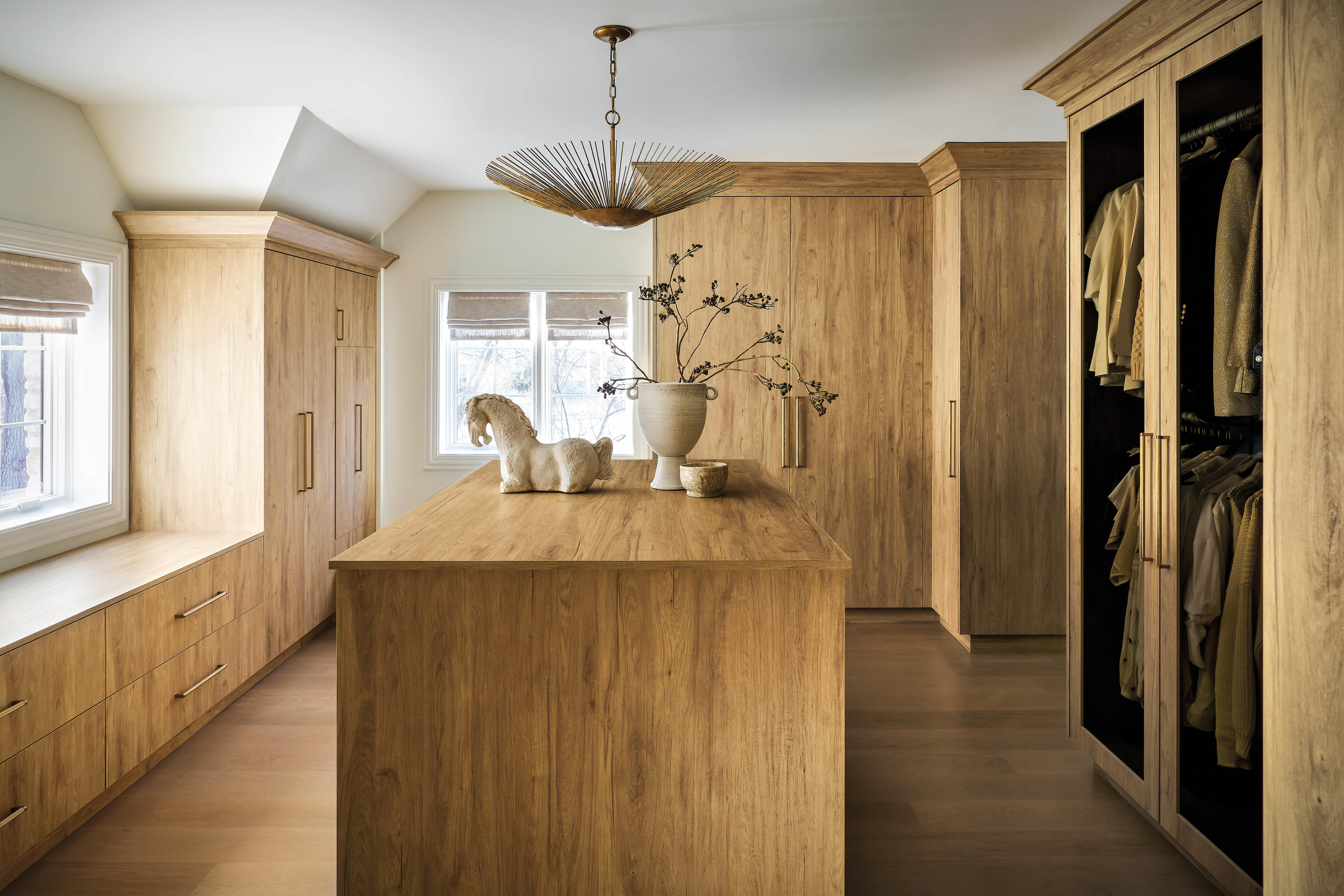 sleek light wood cabinetry lines this dressing room with gold hardware