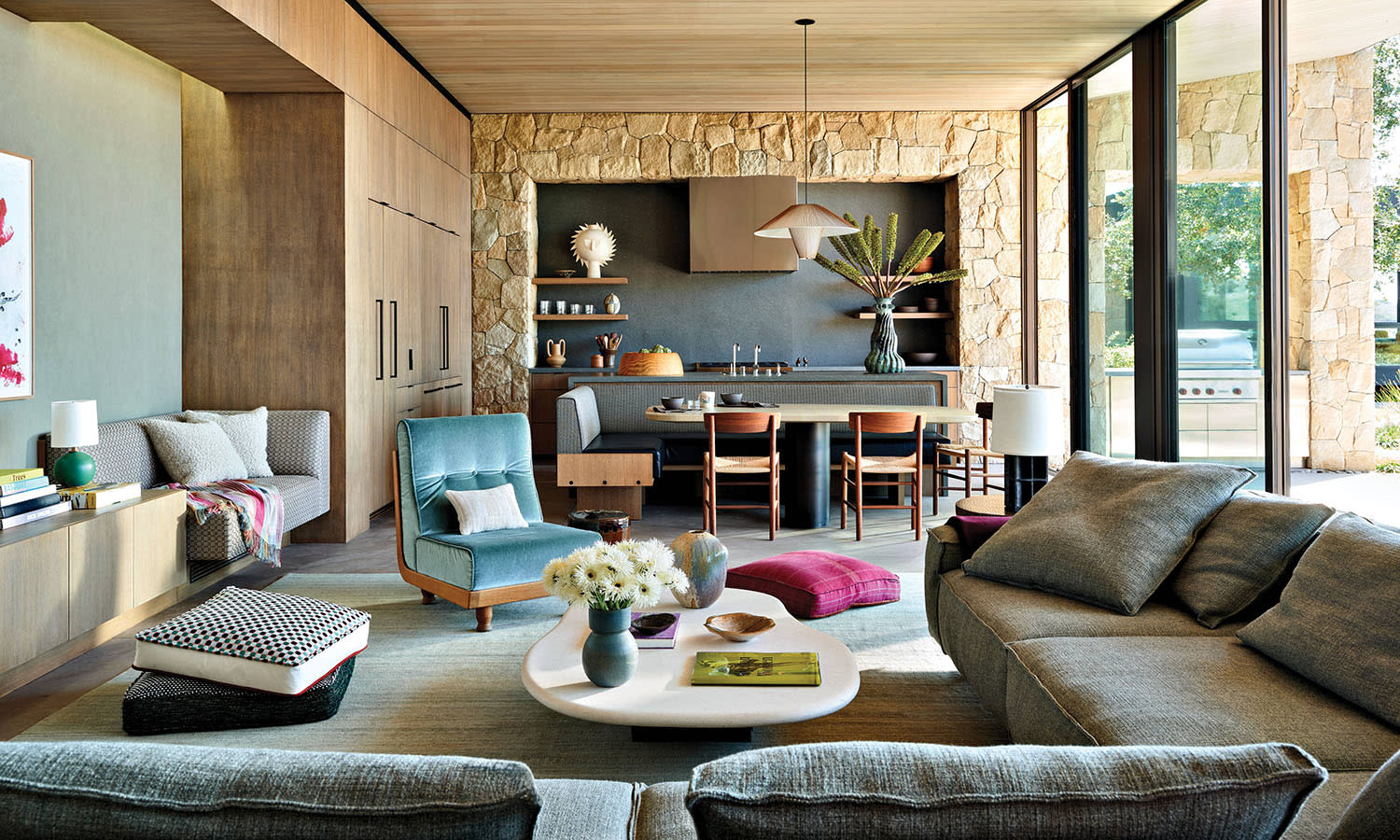 contemporary great room with sandstone accents, grey sectional and a blue slipper chair