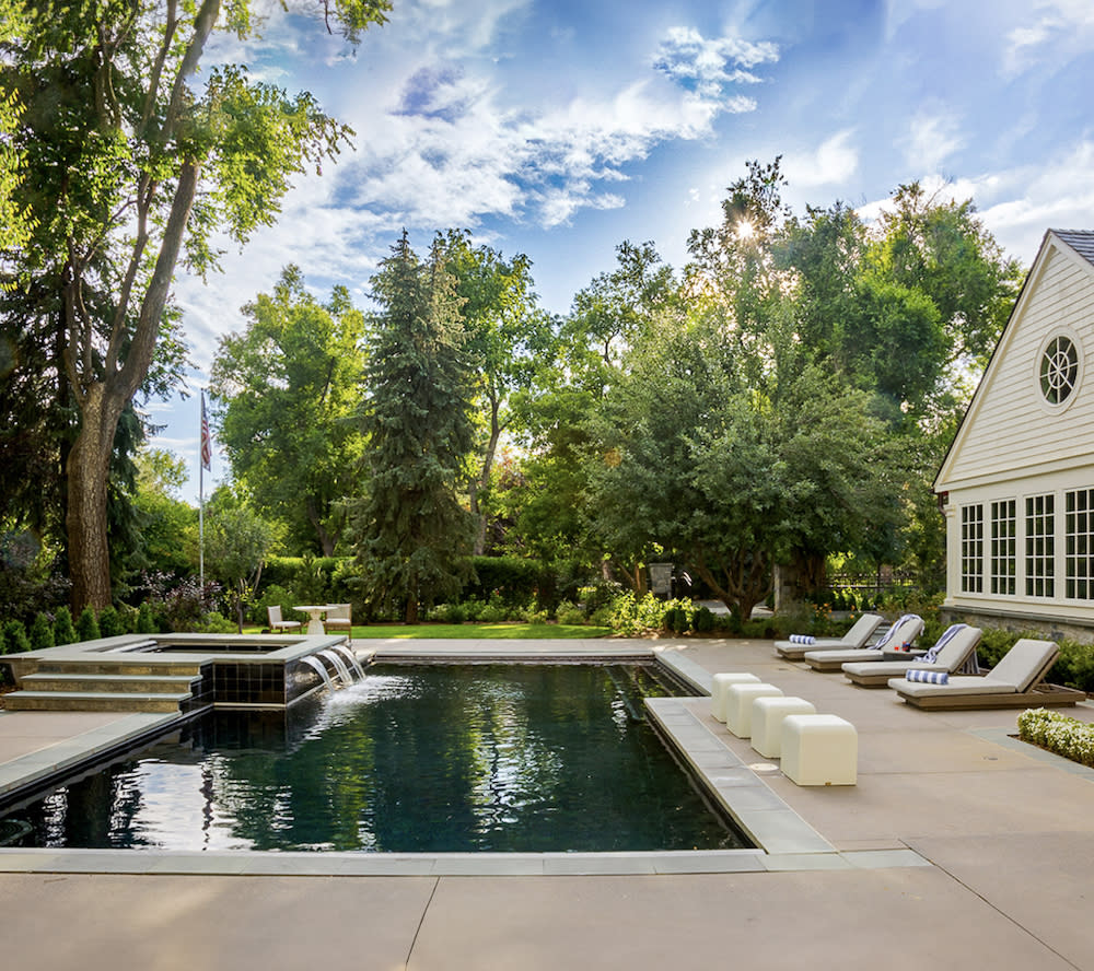 A backyard oasis with a sparkling pool and comfortable patio furniture, perfect for relaxation and outdoor gatherings.