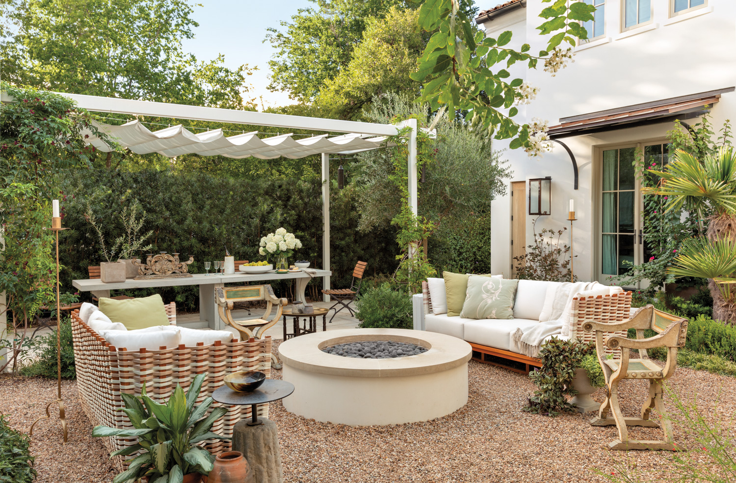 lush courtyard with a fire pit seating area and covered dining area