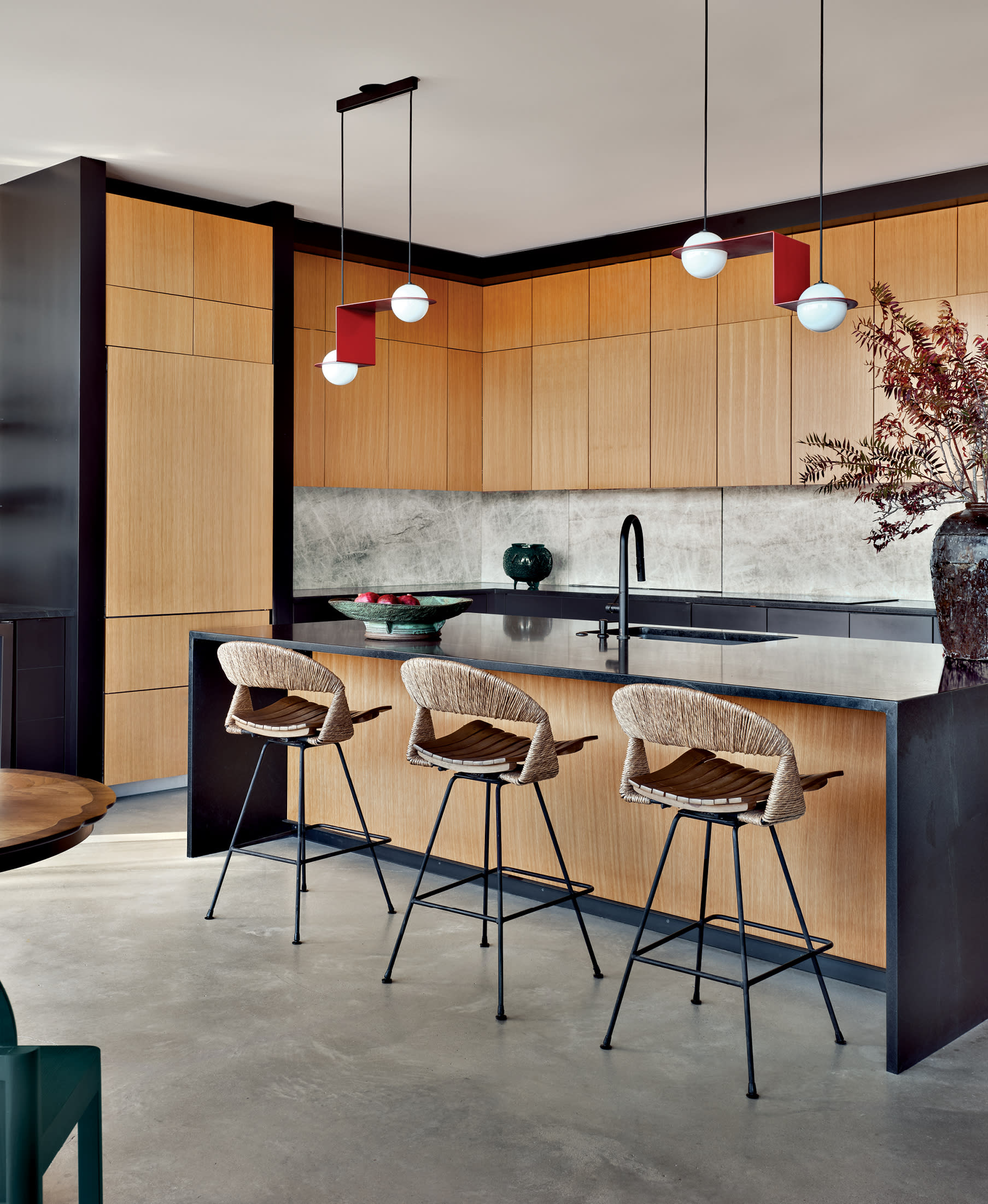 modern kitchen with white oak cabinetry, vintage stools and leathered quartzite countertops