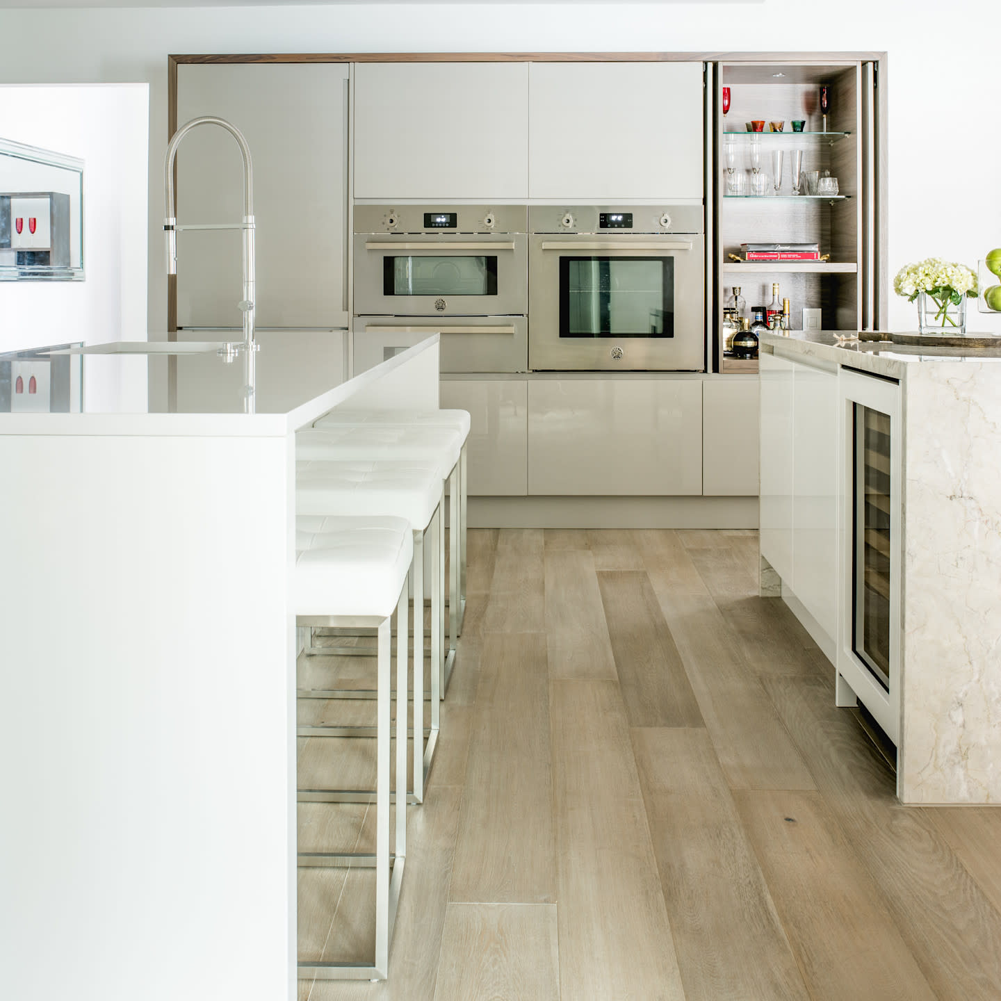 Seamless blend of warm wood cabinetry and softly veined stone surfaces. Clean lines, integrated storage, and a sculptural waterfall island create a calm, architectural space defined by balance, restraint, and refined materiality.

Photo by: Costa Christ
