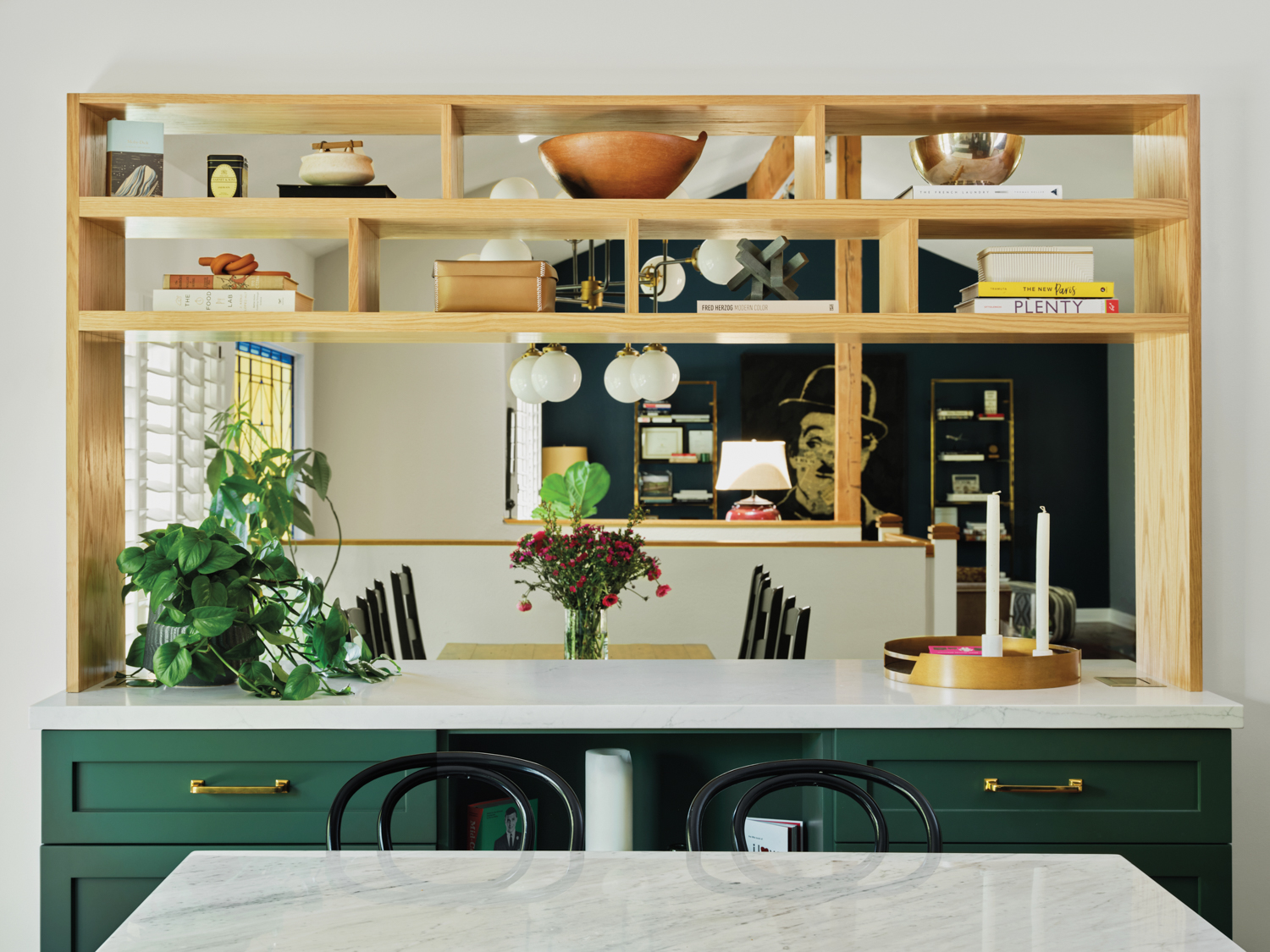 wooden kitchen shelves, green cabinets, and marble countertops