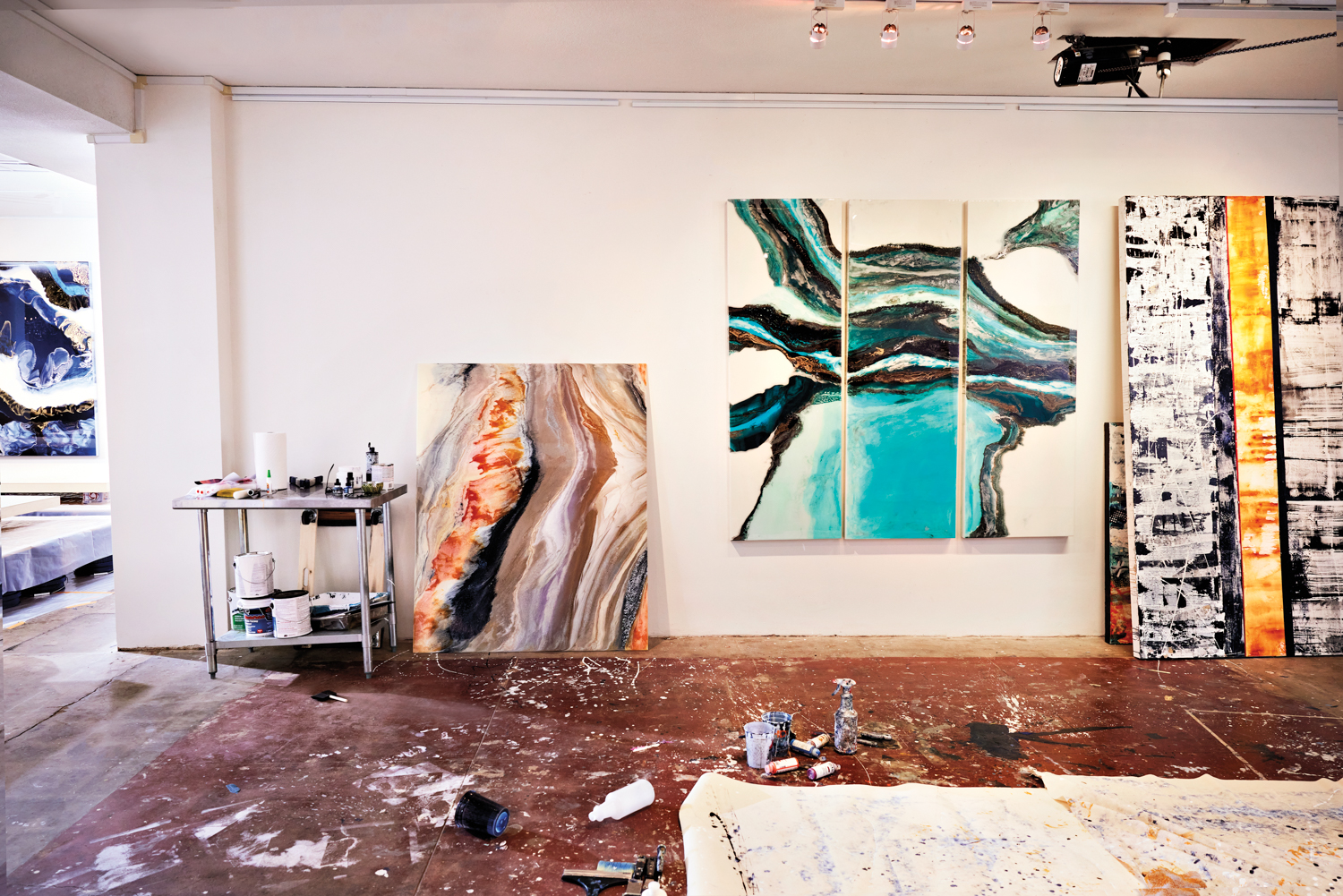 Orange-gray-and-brown abstract painting, a blue-and-white abstract triptych and a black-white-and-yellow abstract