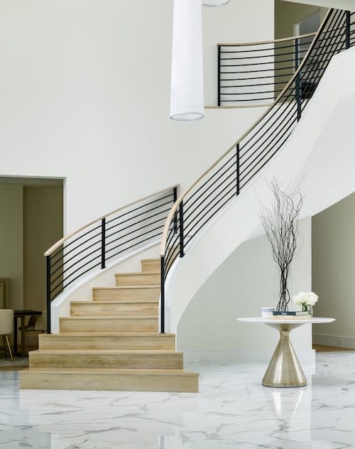 A grand foyer with a beautiful staircase, blending various elements to create a stunning entrance.