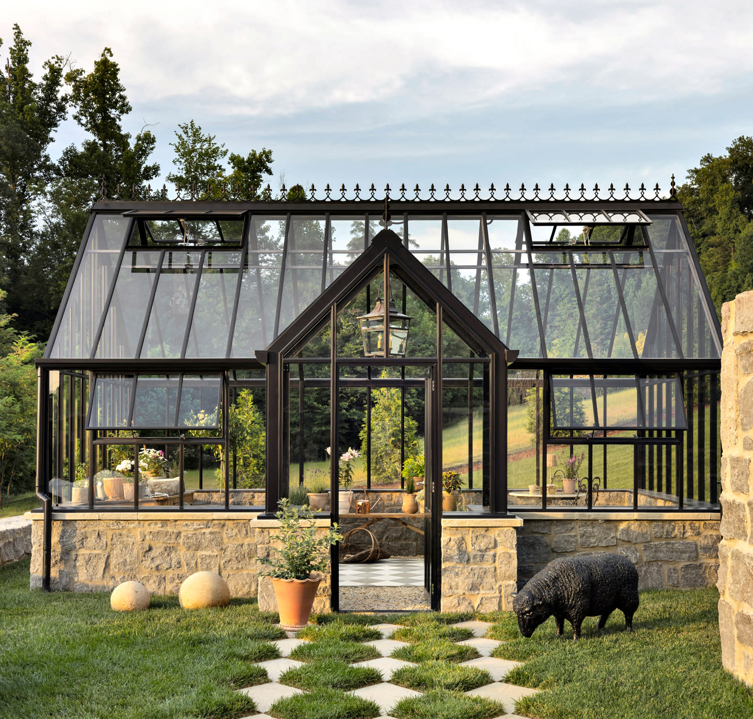 A large glass greenhouse serves as an entertainment space, showcasing a bright and airy environment for growth.