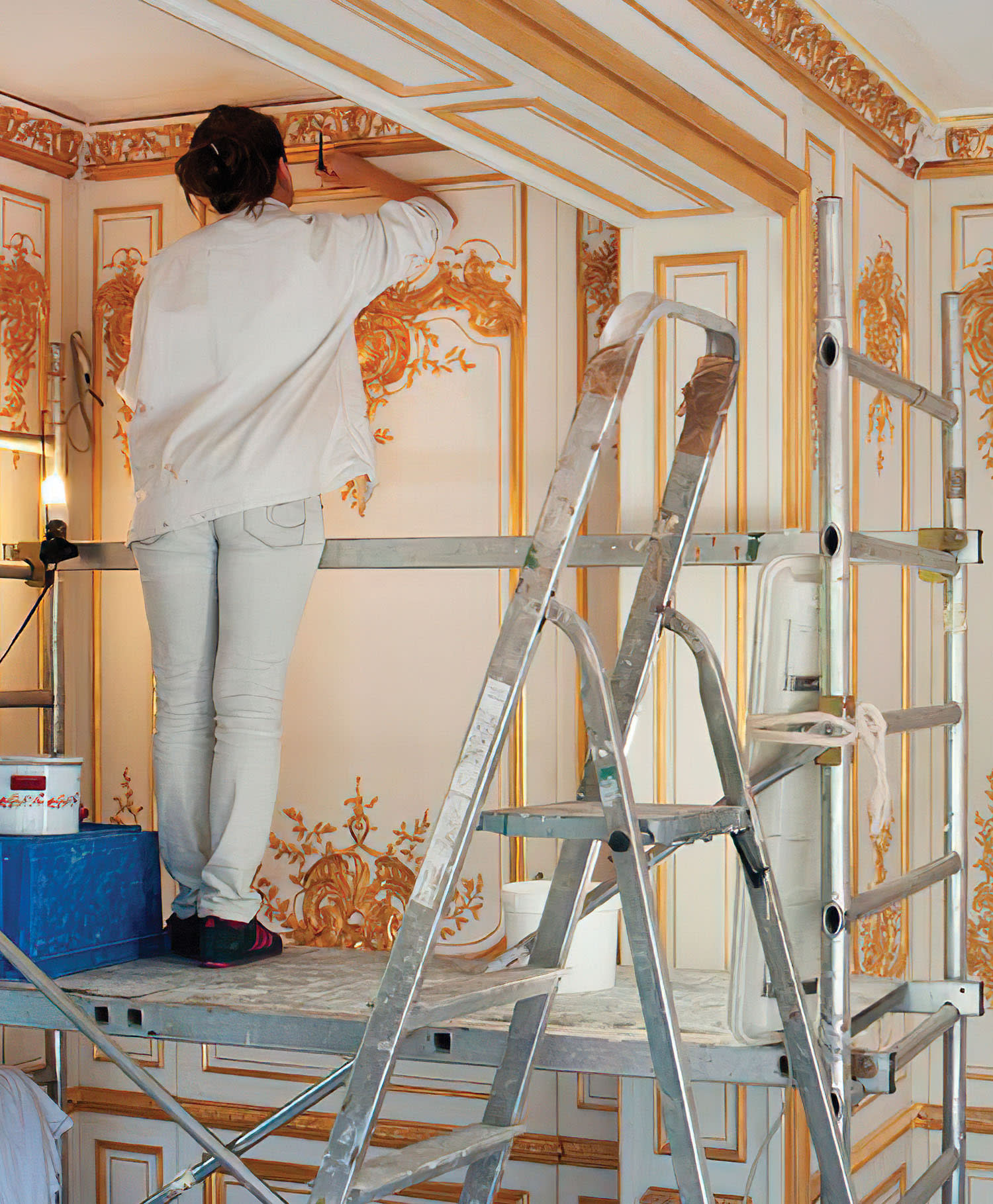 a craftsperson applies gold leaf using a water gilding technique at Féau Boiseries