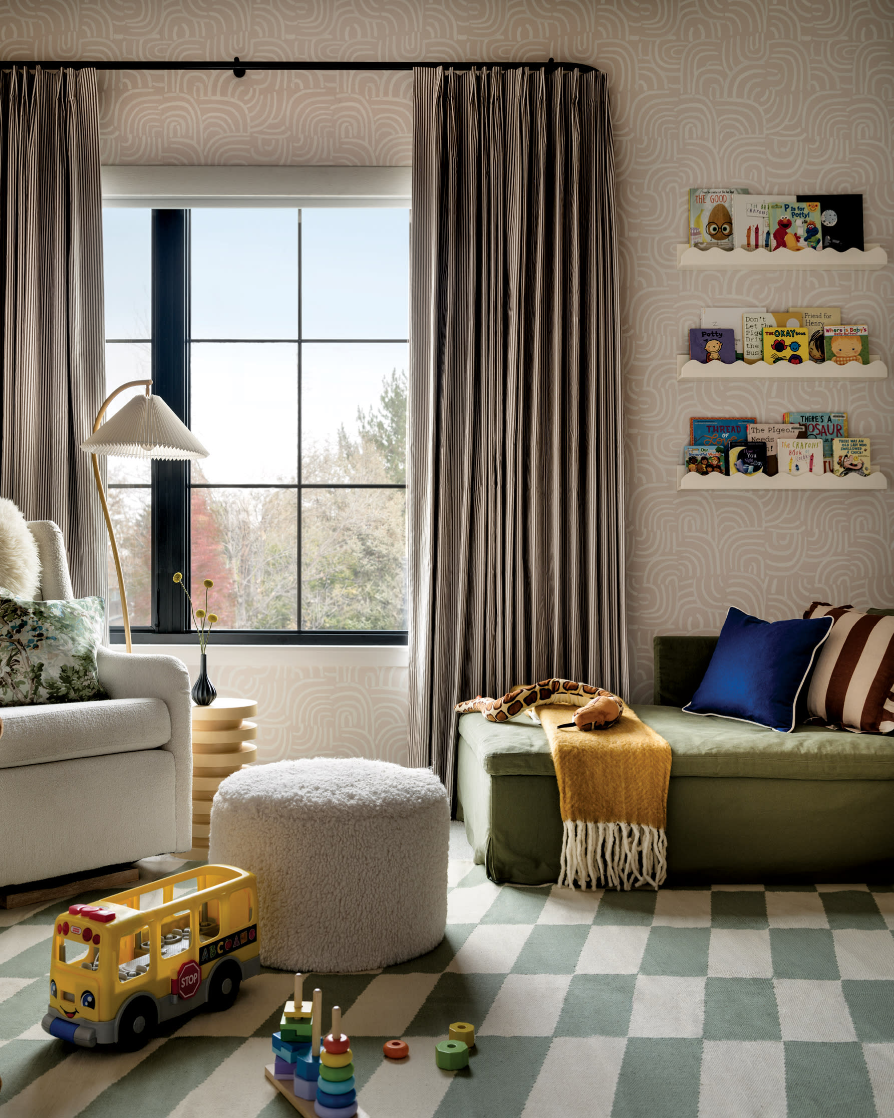 nursery with a green and white checkered rug and toys on shelves on the wall