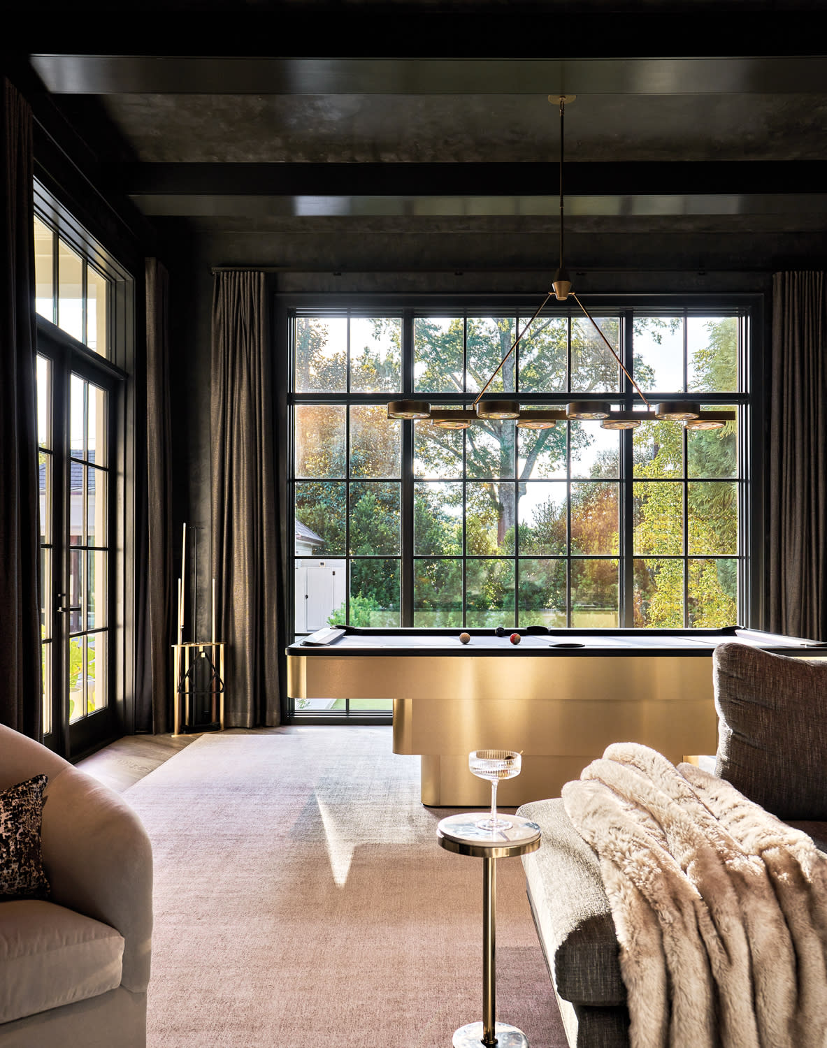 lounge with dark-tinted plaster, a brass-base pool table and swivel chairs