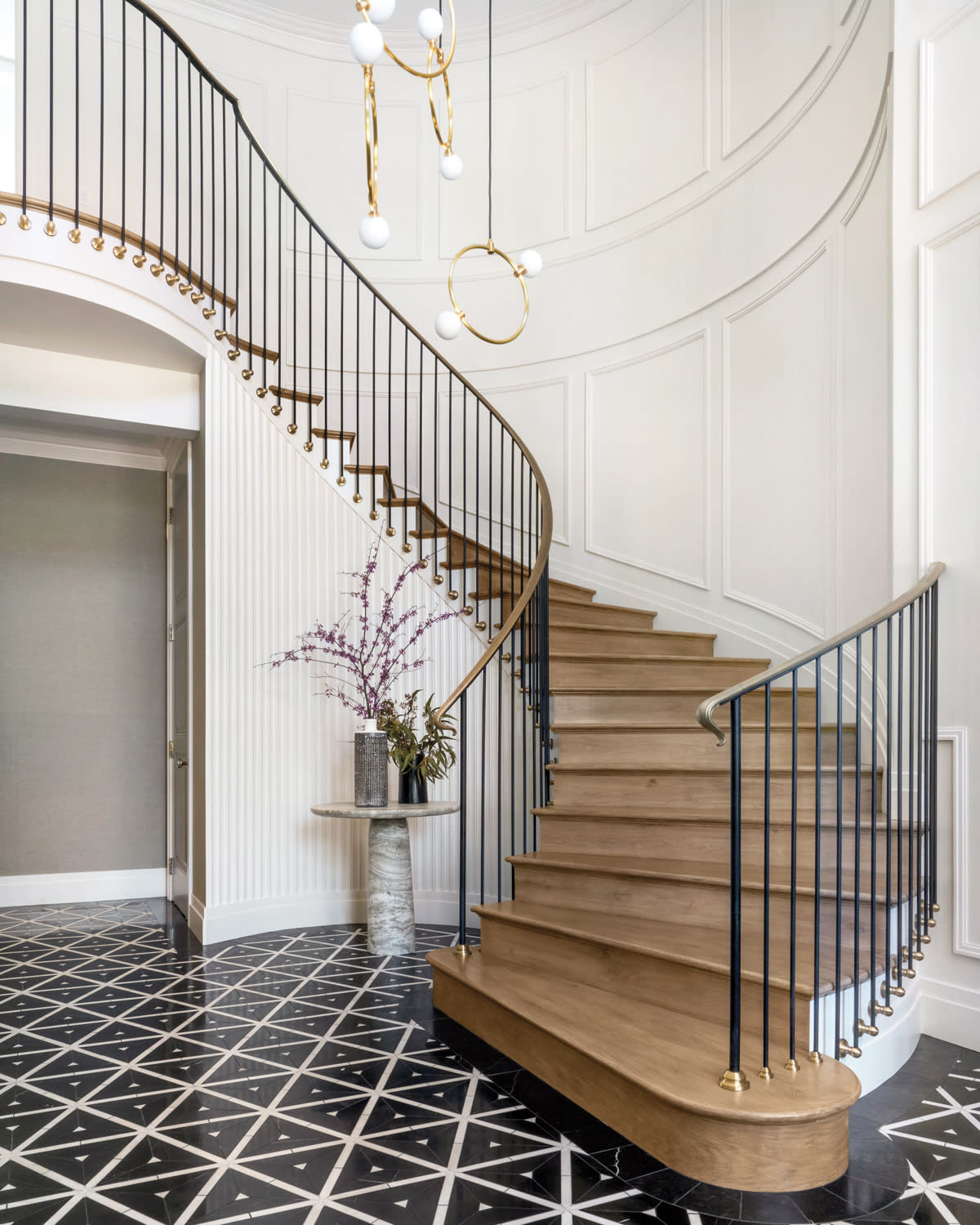 entrance hall with spiraling staircase with brass railing