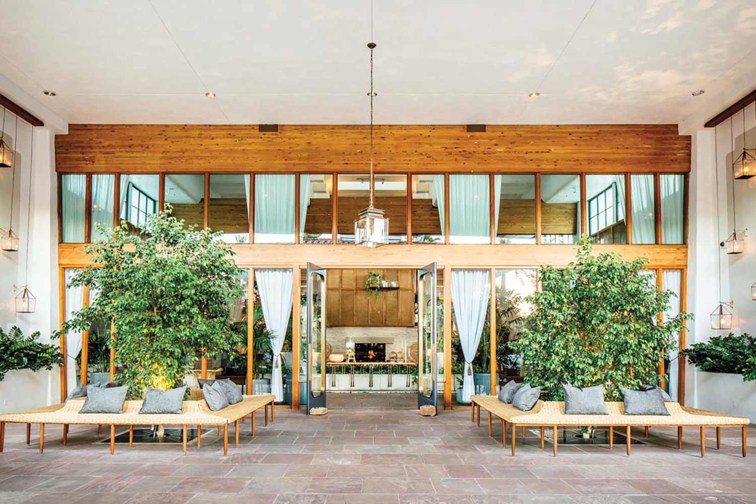 Resort entrance with wood accents, large windows and greenery.