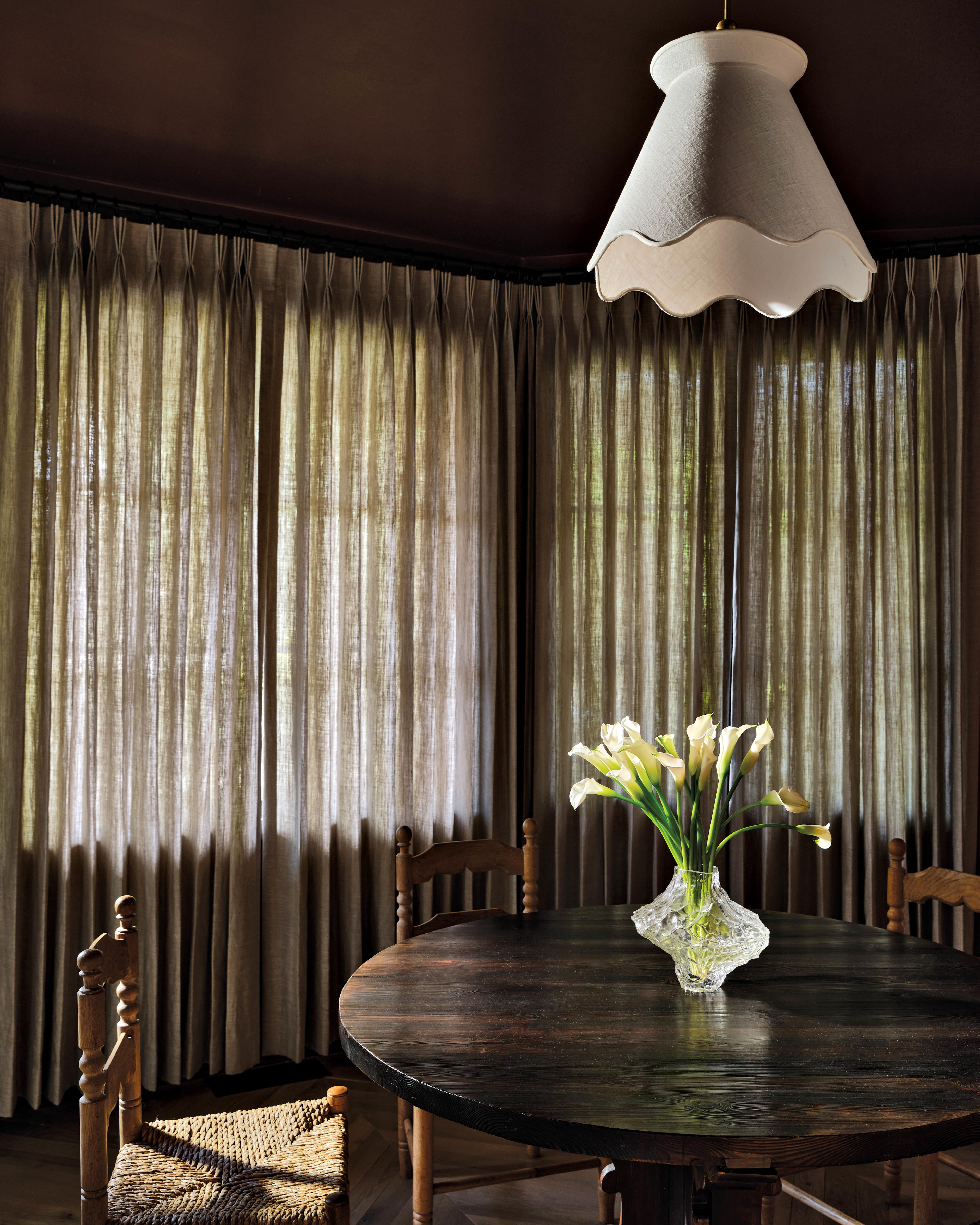 white scalloped edge pendant hanging over a dining table