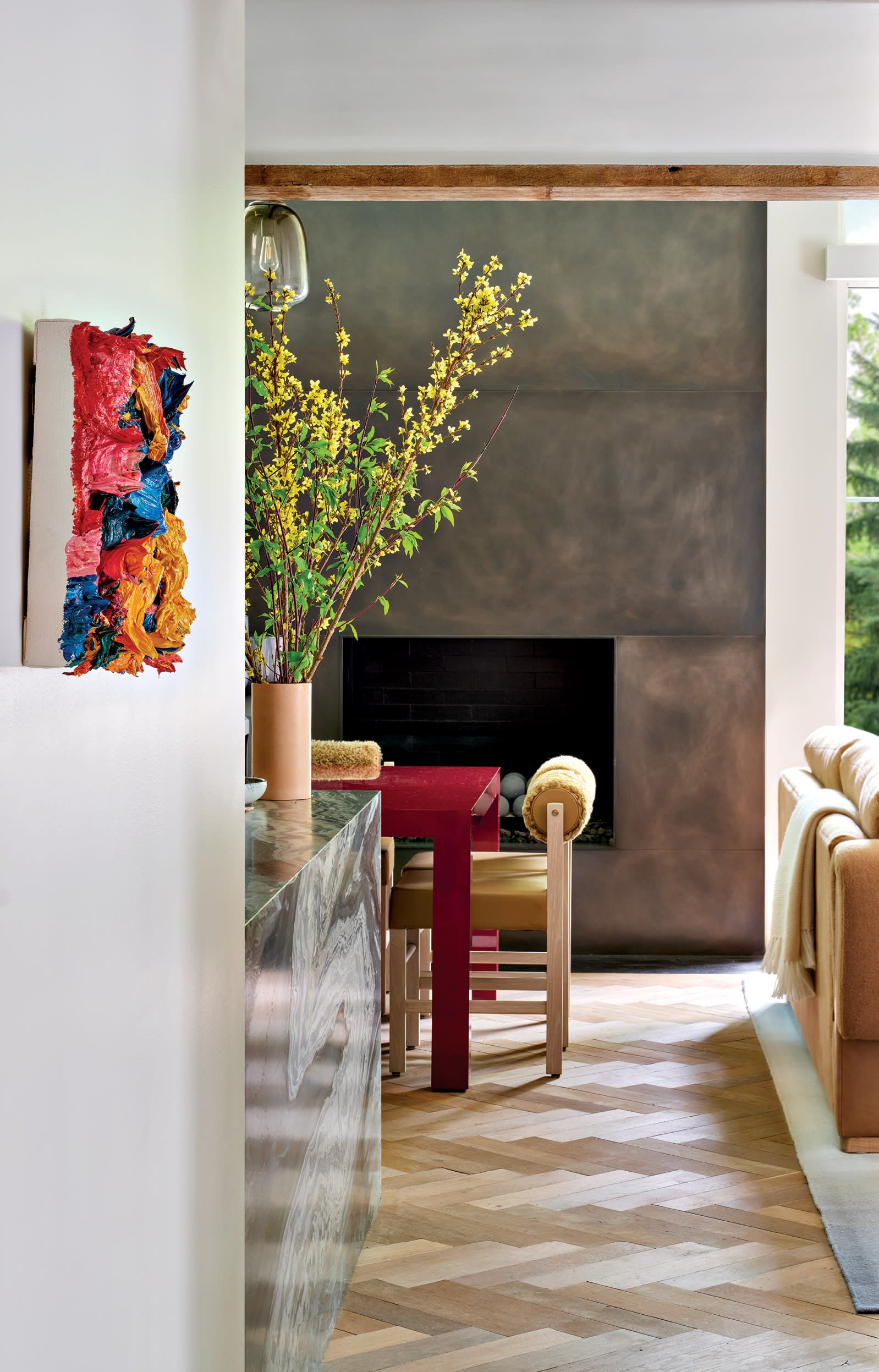 An impasto painting by Zhu Jinshi hangs in the walkway leading into a contemporary dining area