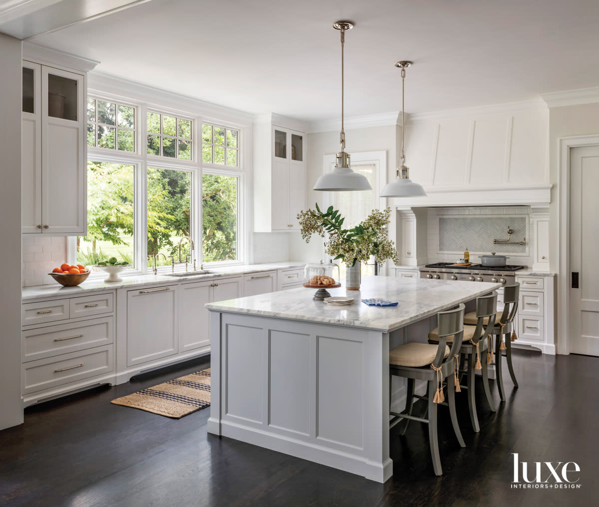 Kitchen with blue painted island and saber leg style bar stools