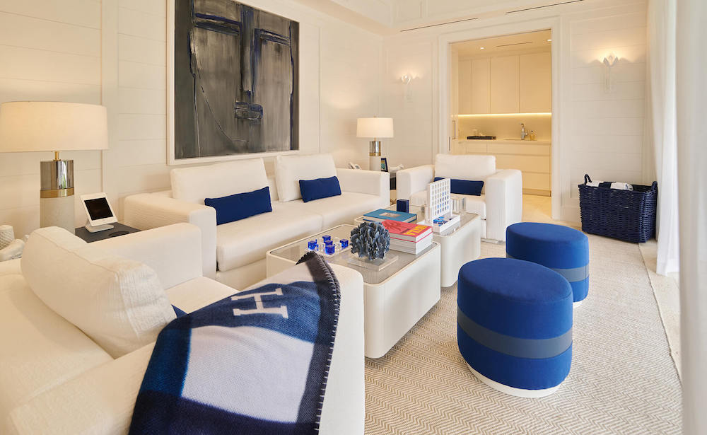 A contemporary white living room showcasing blue furniture and a colorful painting, enhancing the room's aesthetic appeal.