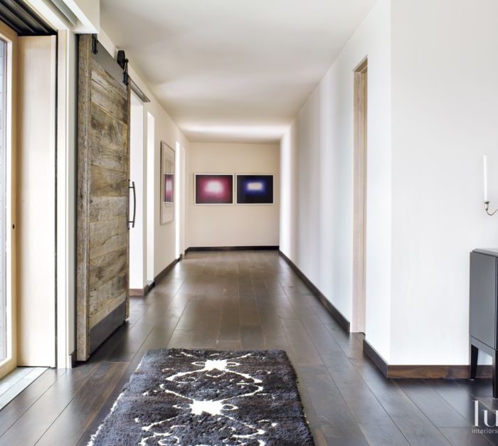 hallway showing rustic barn door that closes home office