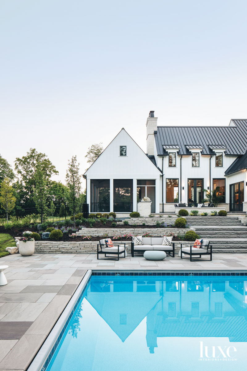 farmhouse exterior with terraced patio and pool