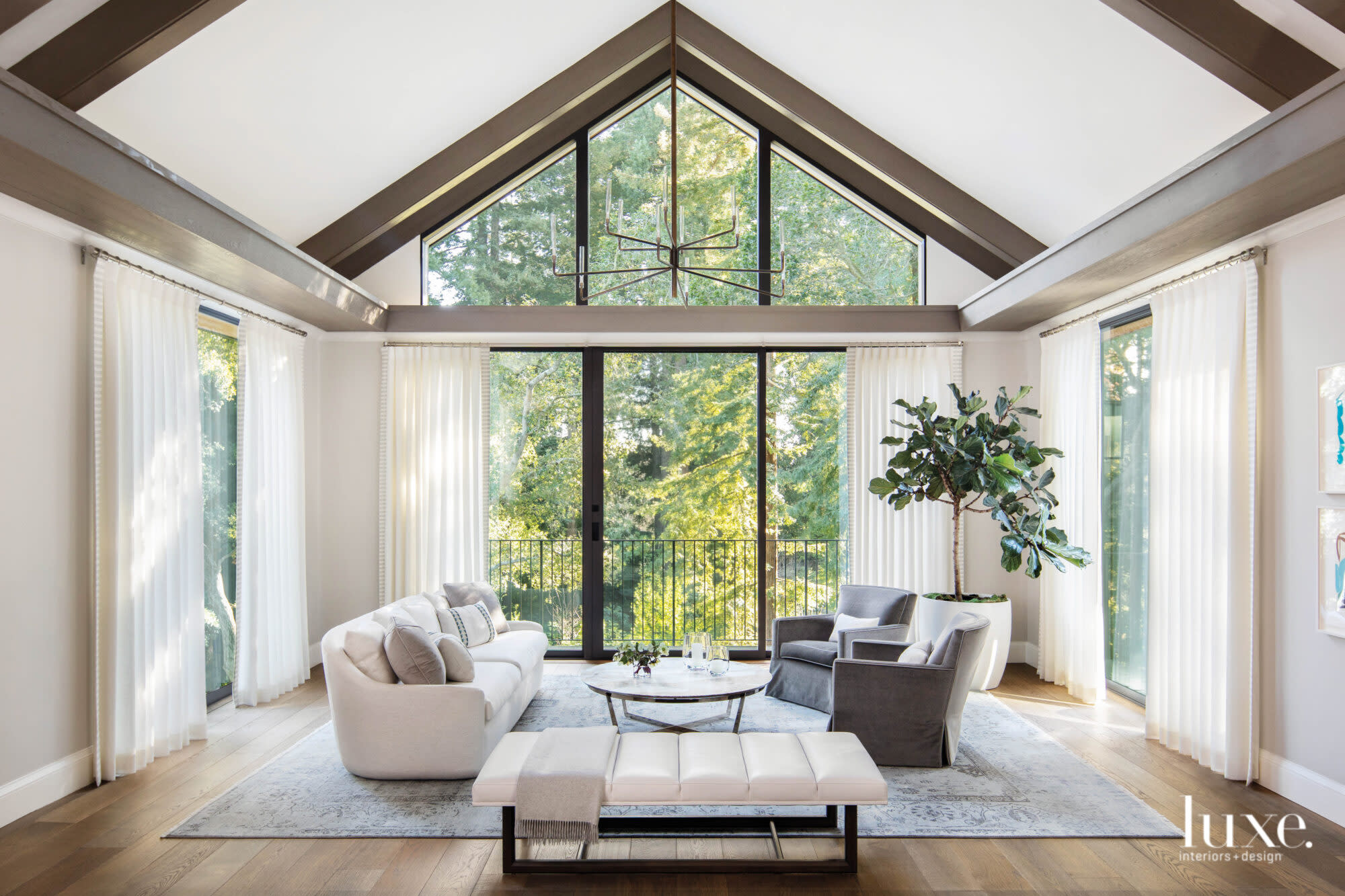 On the other end of the living room, a seating area is in front of large windows.