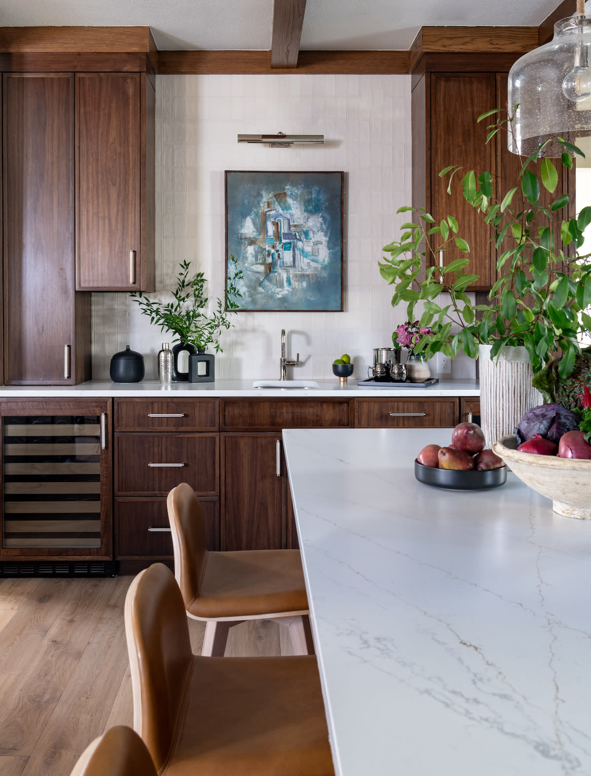 A kitchen with wood cabinets and marble counter tops.