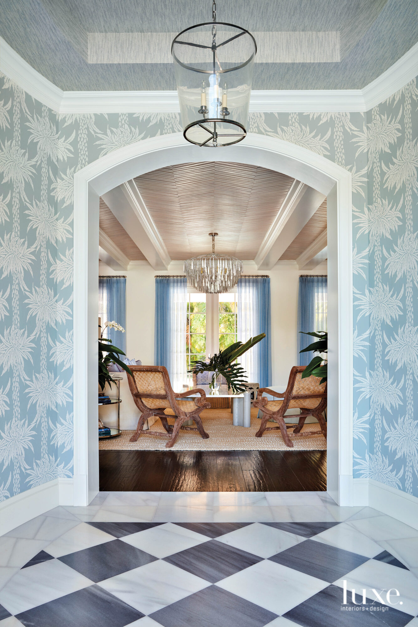 Foyer with blue and white wallcovering with palm tree pattern.