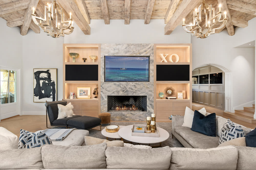 Warm, neutral, living room with fireplace and large TV.