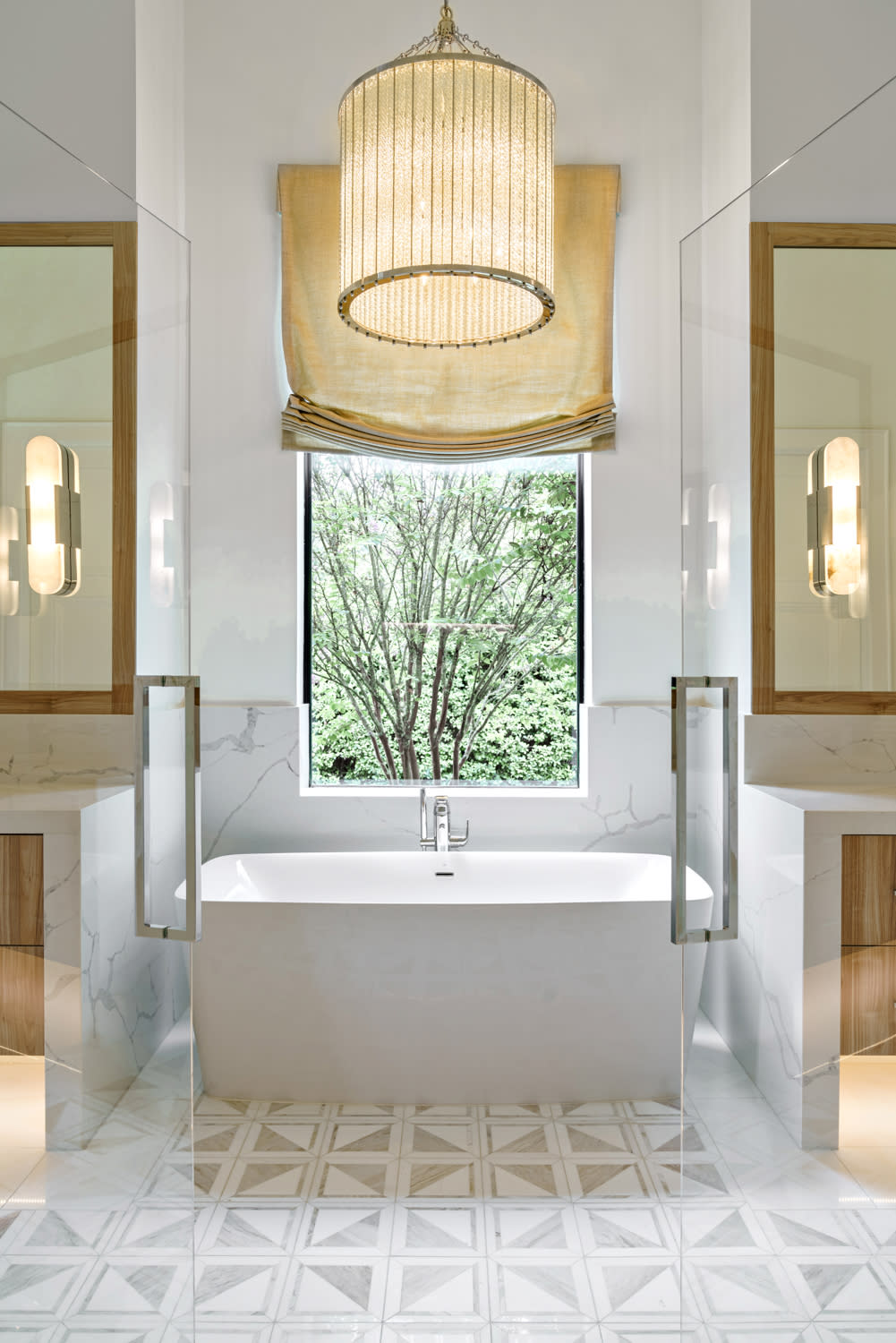 white bathroom with a large window above the tub showcasing forest views