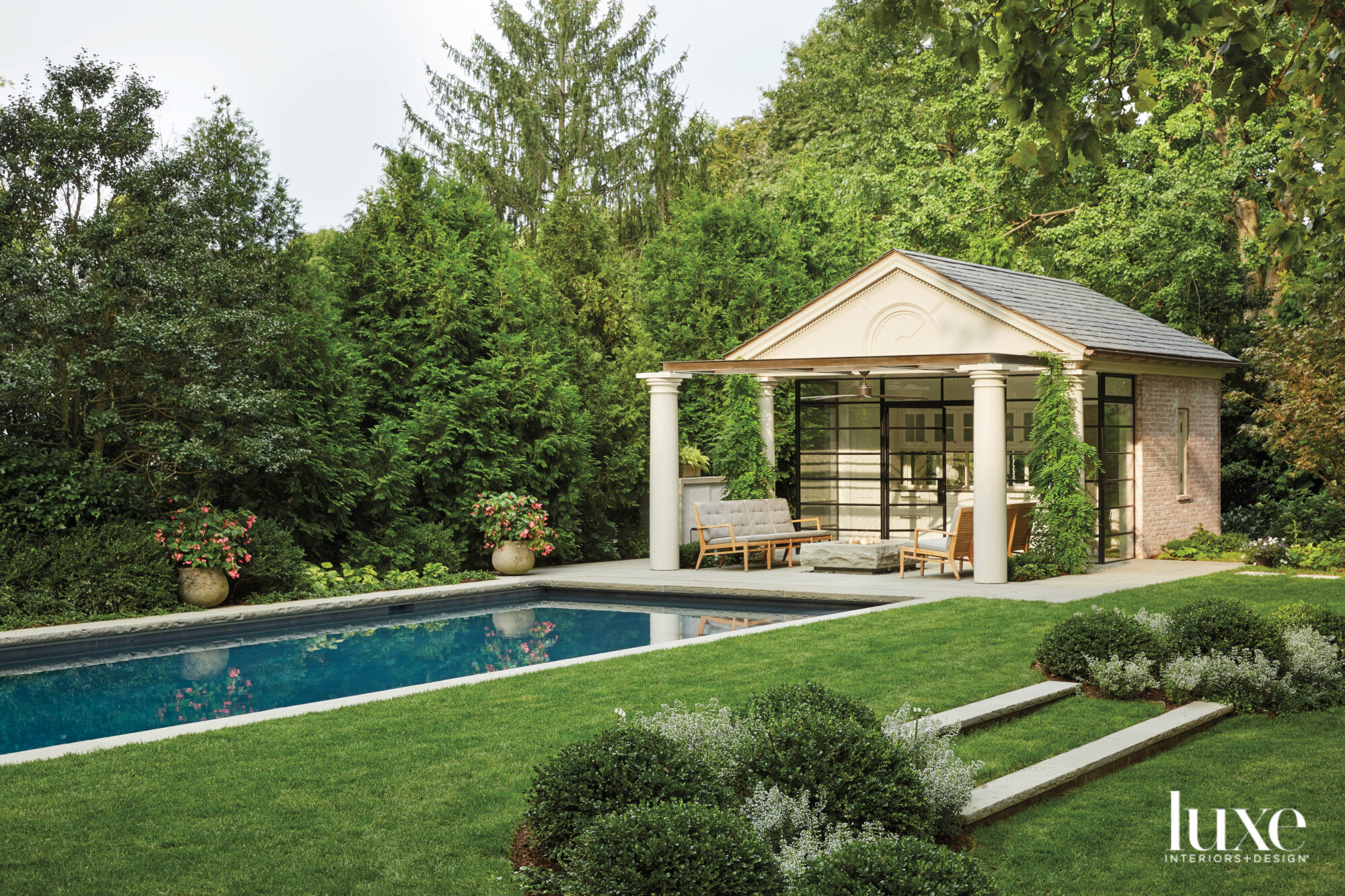 lush greenery, pool house and stone fire pit serve as inspiration for modern garden designs