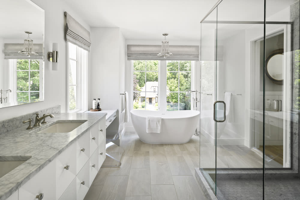 Large primary bath with freestanding tub and glass shower. 