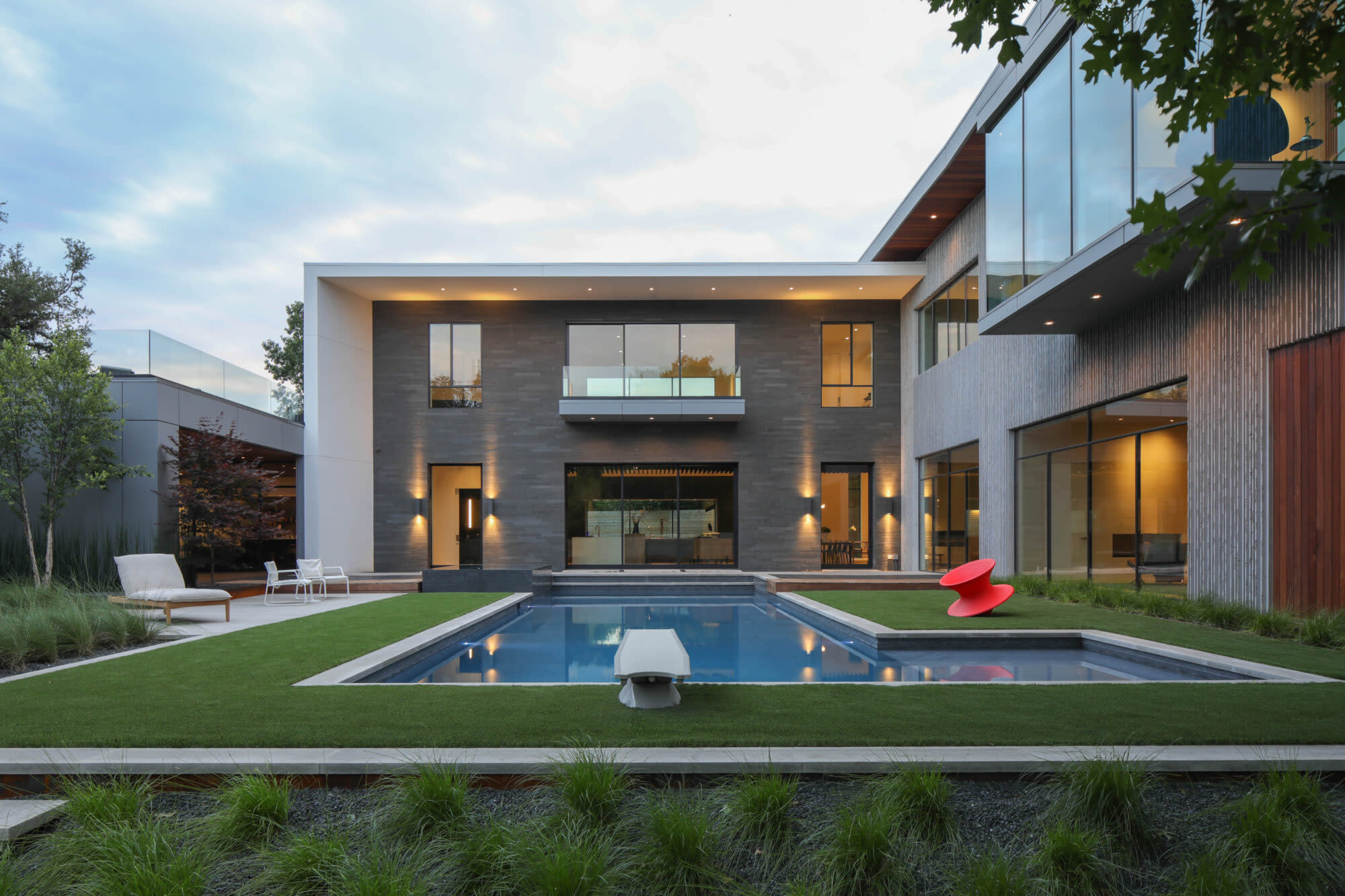 Symmetrical modern estate with central pool and turf detailing