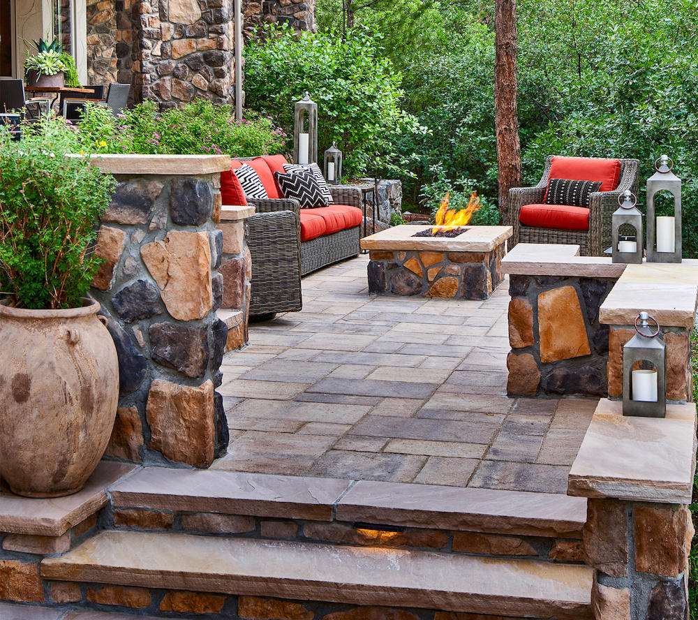 Seating area around fire pit on stone patio.