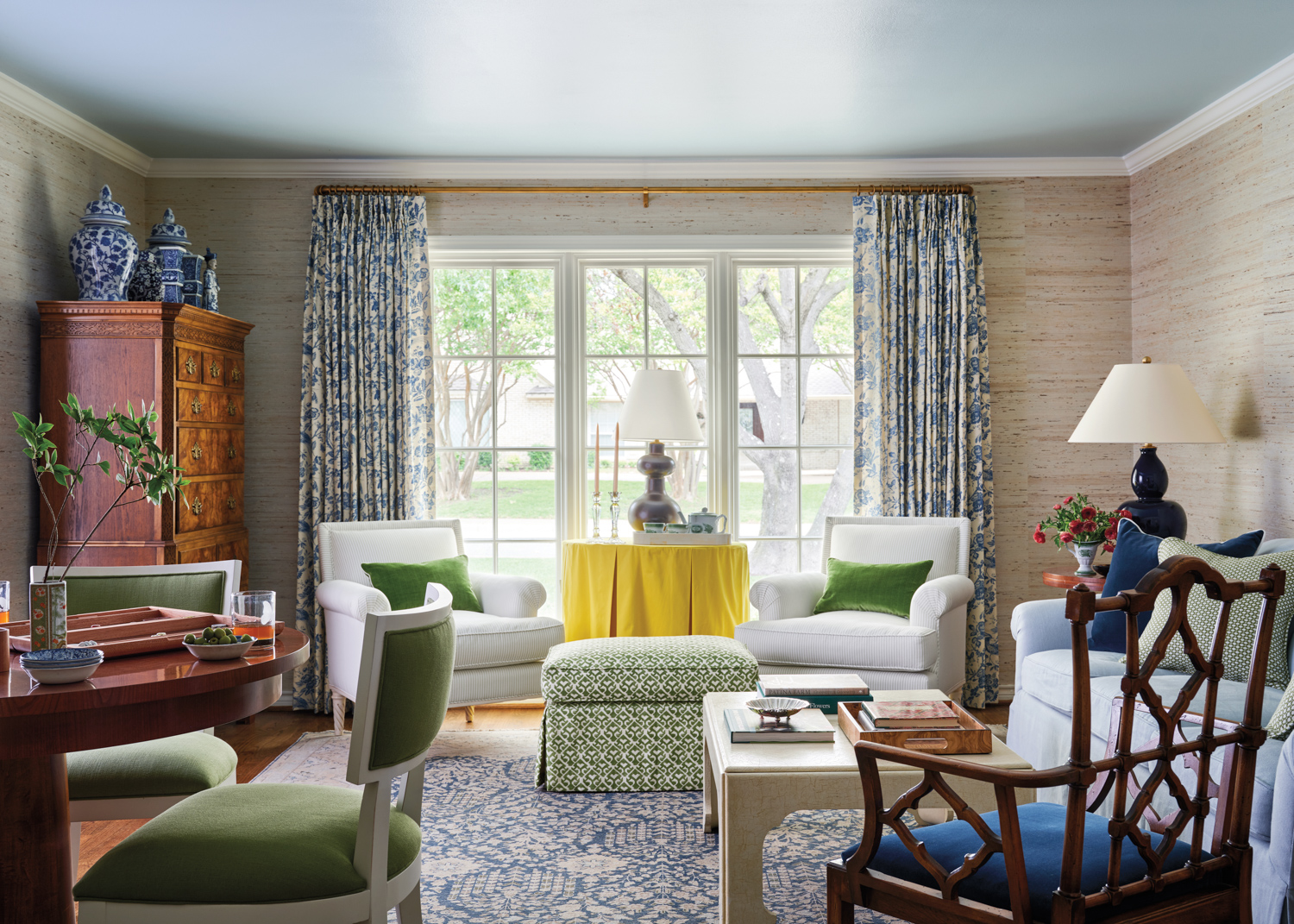 Living room centered by large window with blue-and-white drapes