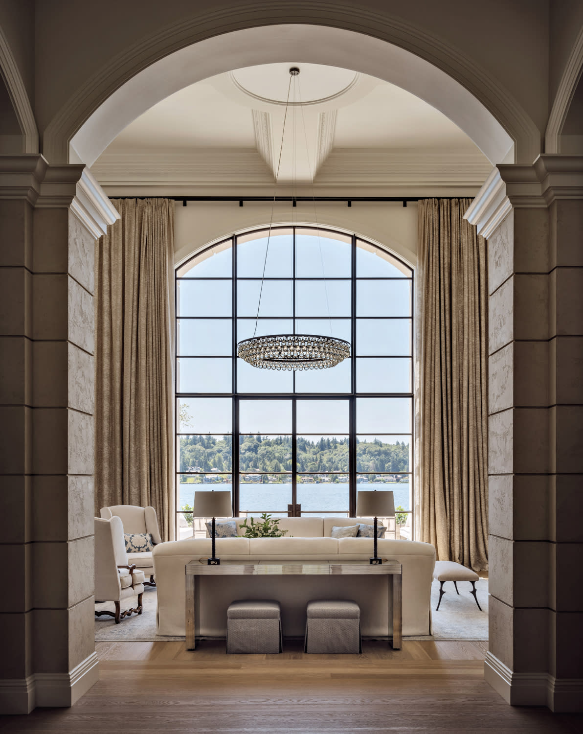 classic living room with an arched doorway and views of the water outside a large window