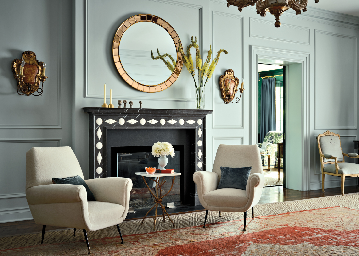 traditional living room with light blue walls and black-framed fireplace