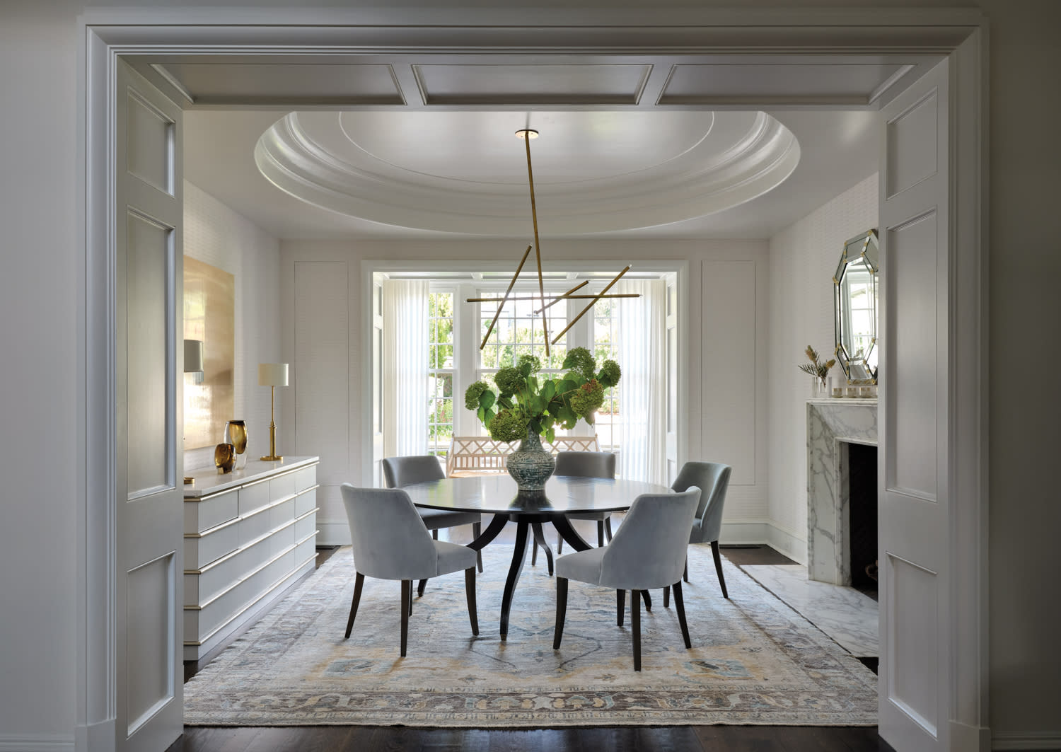 A dining room featuring a circular table surrounded by several chairs.