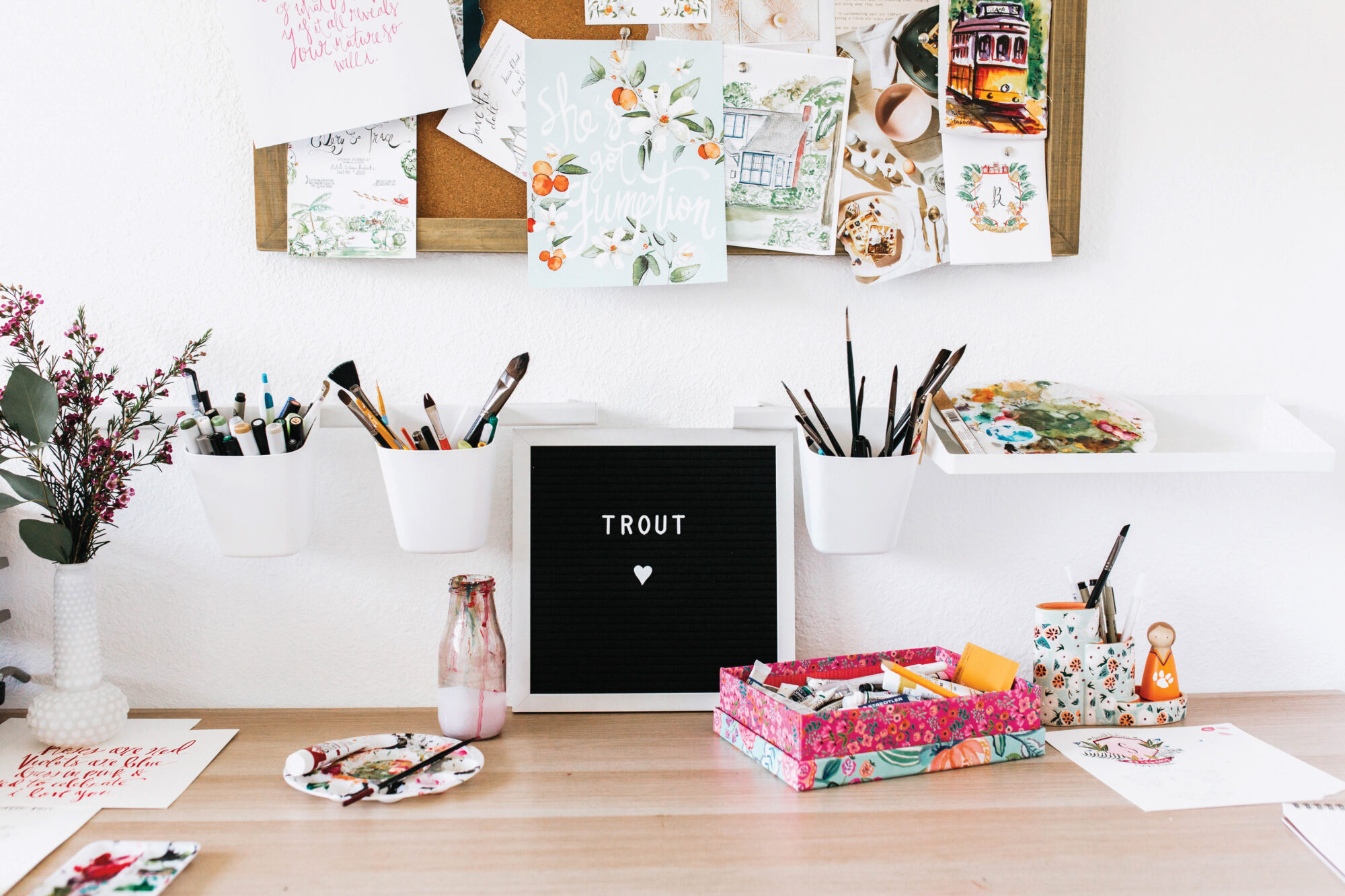 Studio space with art on walls, paint and brushes