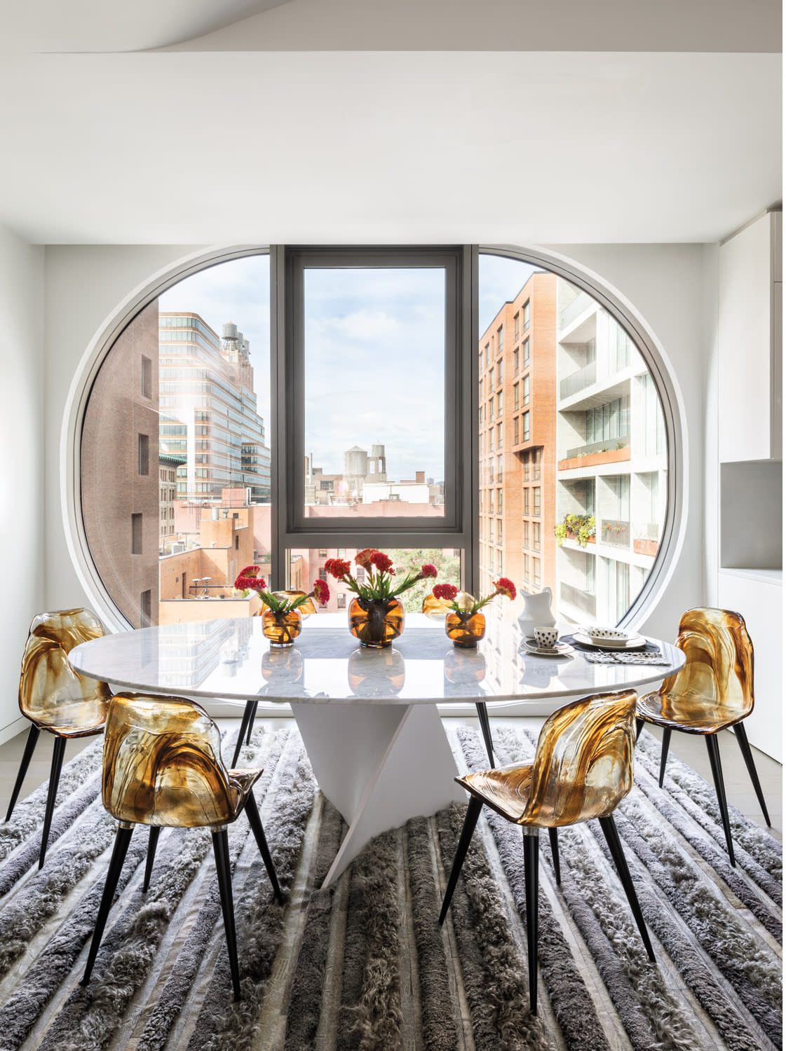 modern white dining table with resin chairs and hide rug