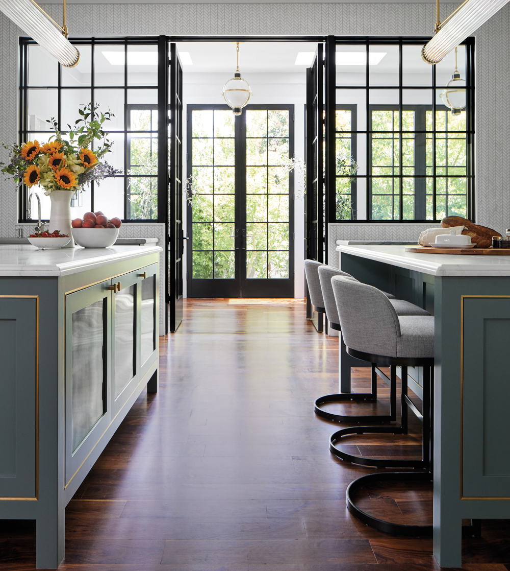 bright kitchen space with windows and dark green metal cabinets by Studio Heimat