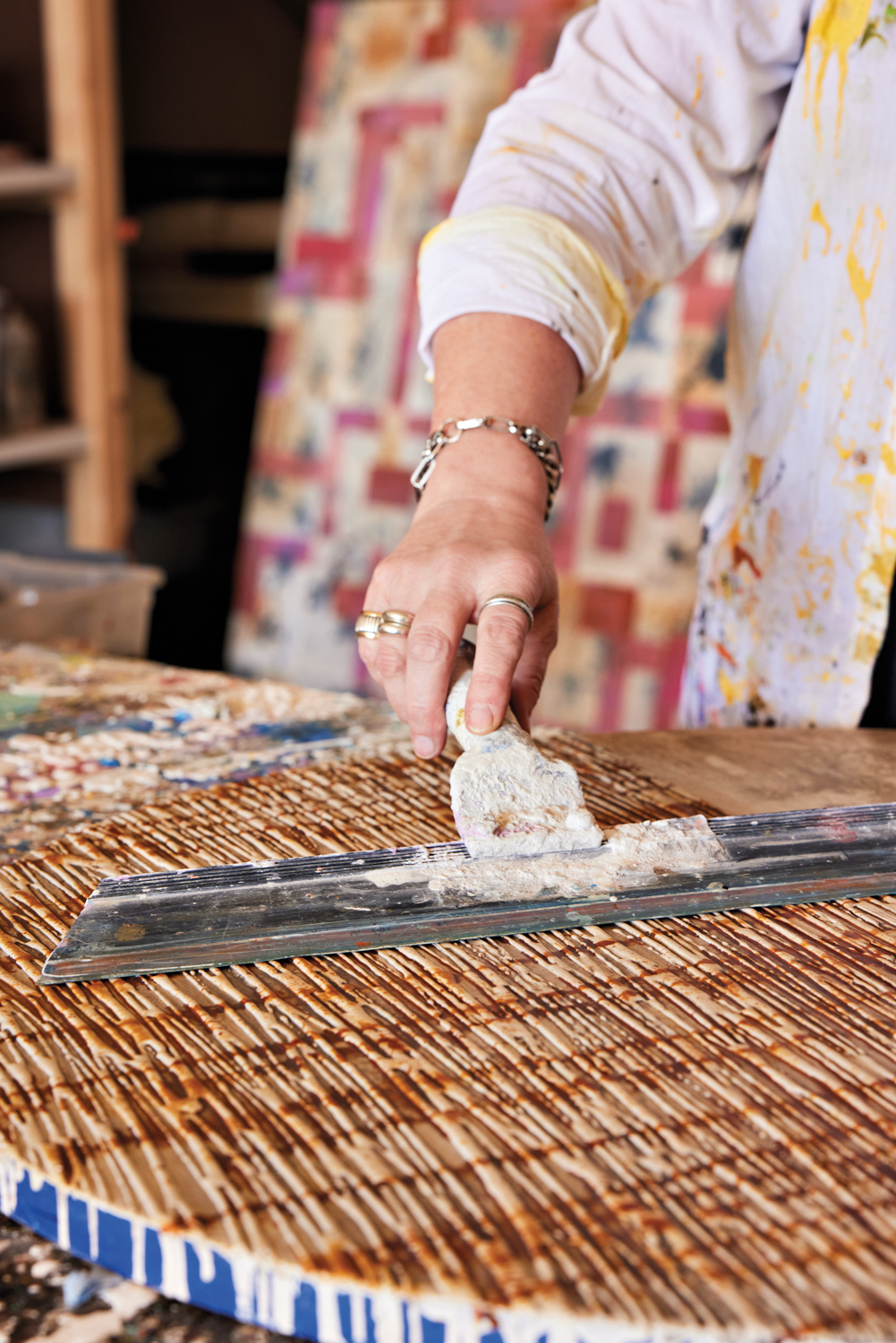 Kathleen Hope spreading cement on a wooden board