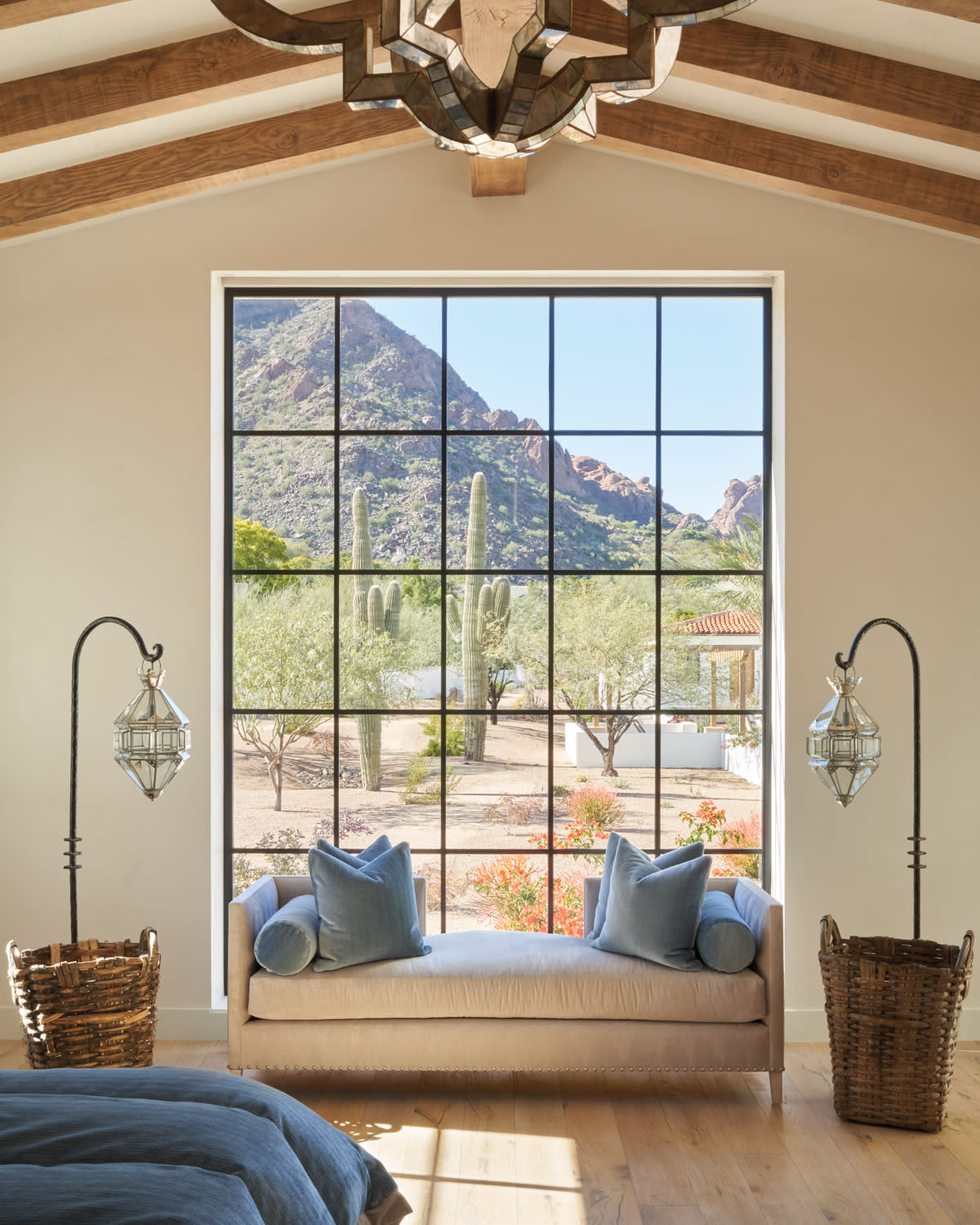 upholstered chaise and pair of floor lamps in front of steel-and-glass windows